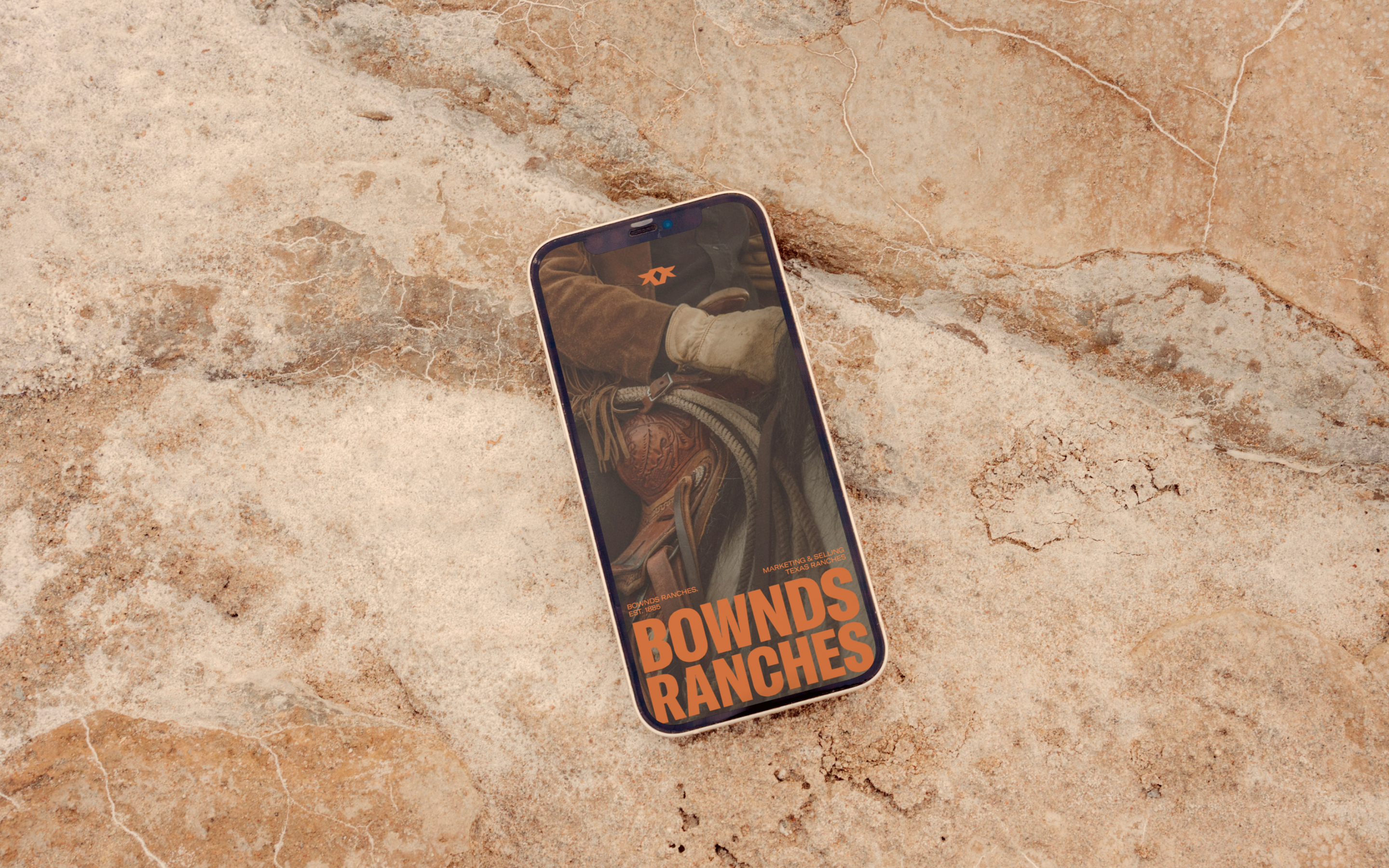 Bownds Ranches website on a mobile phone sitting on a sandstone background