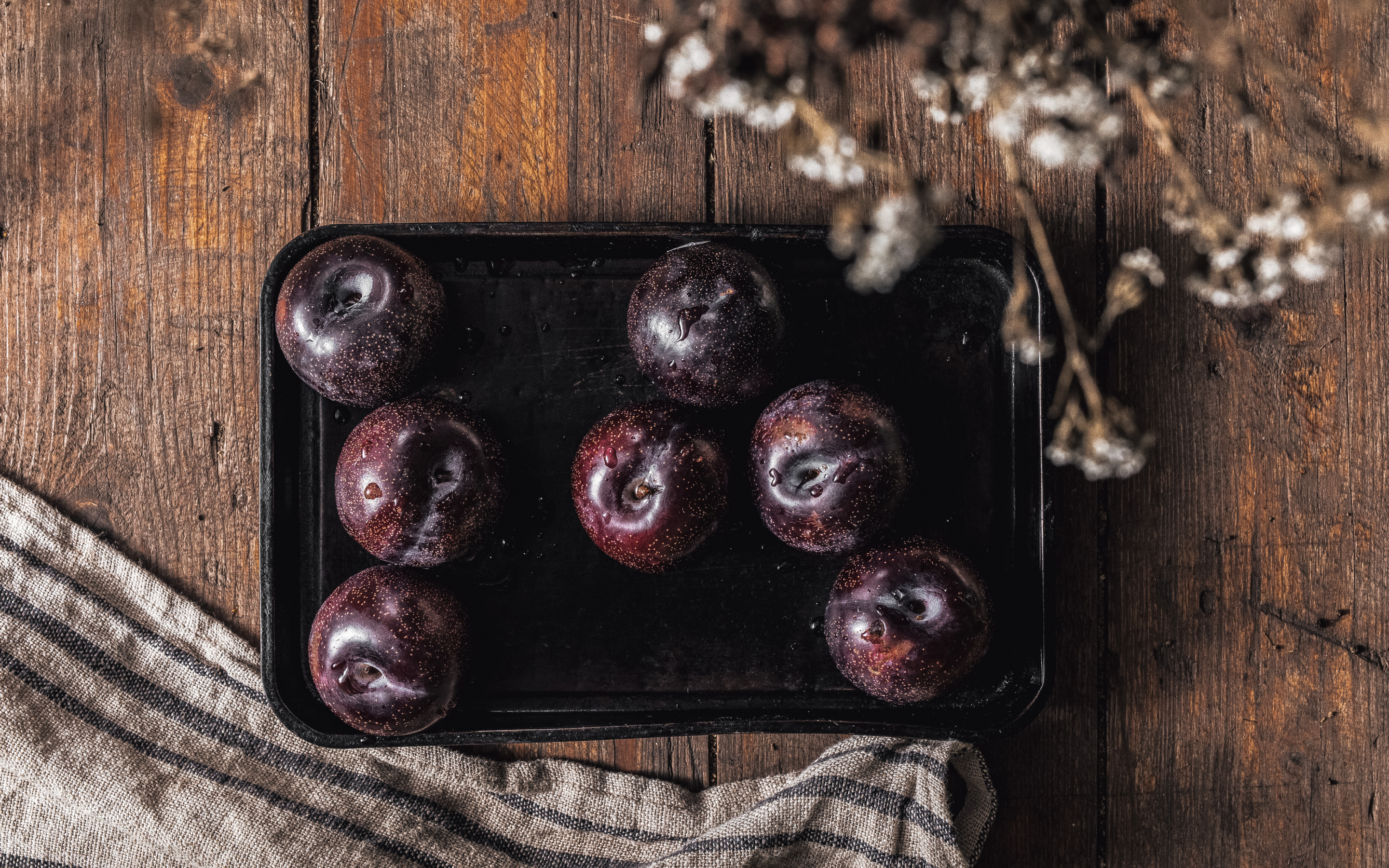 Tray of Queen Garnet plums sat on a wooden table