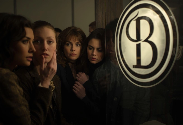 A group of women making judement in front of a sign