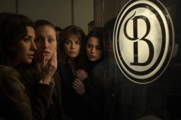 A group of women making judement in front of a sign