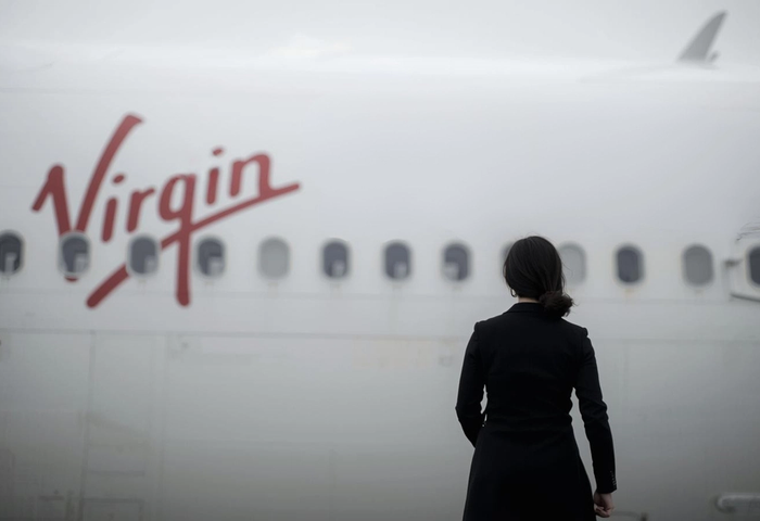 A lady standing in front of a plane