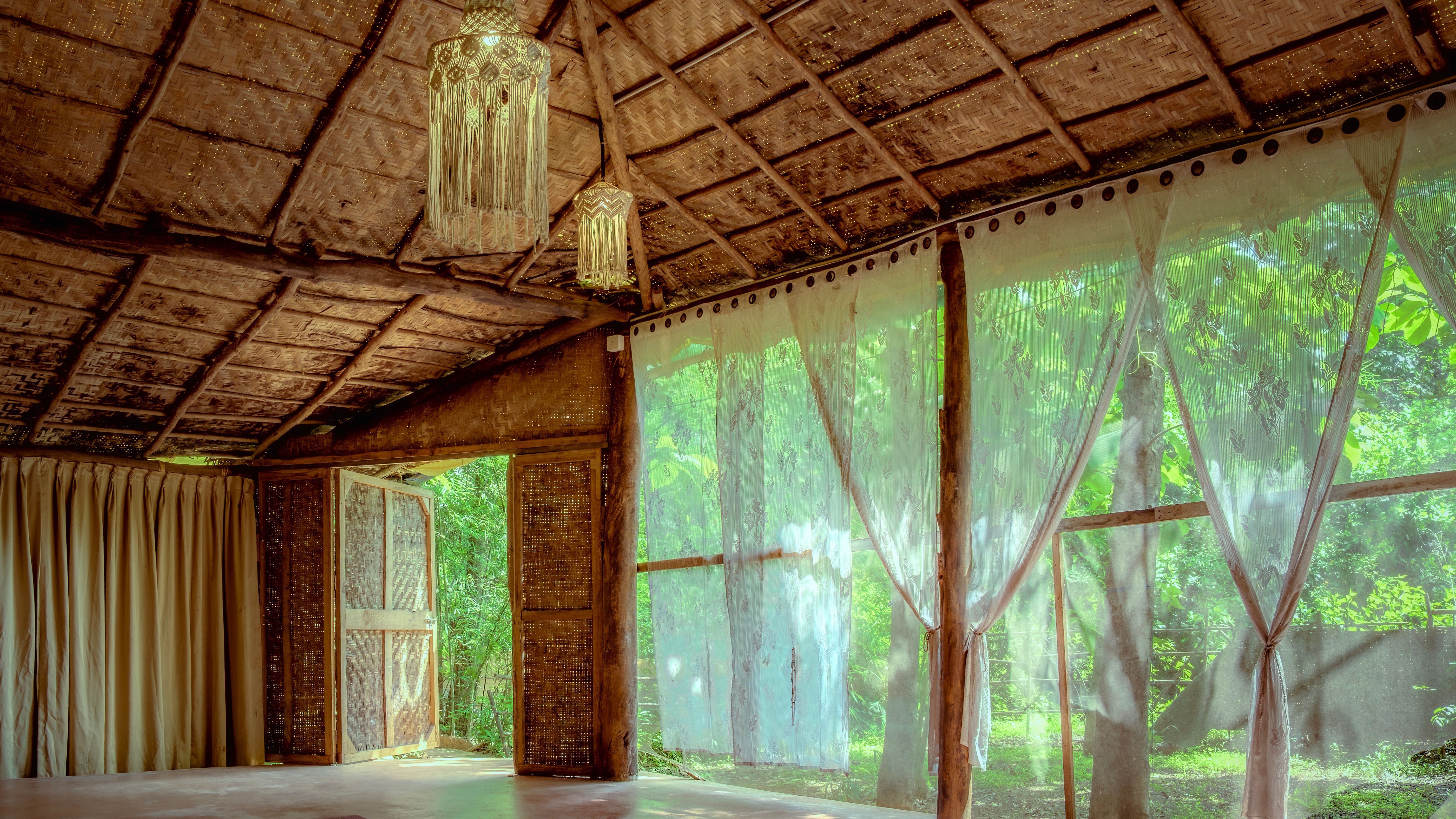 Open-air yoga hall beneath a traditional thatched roof