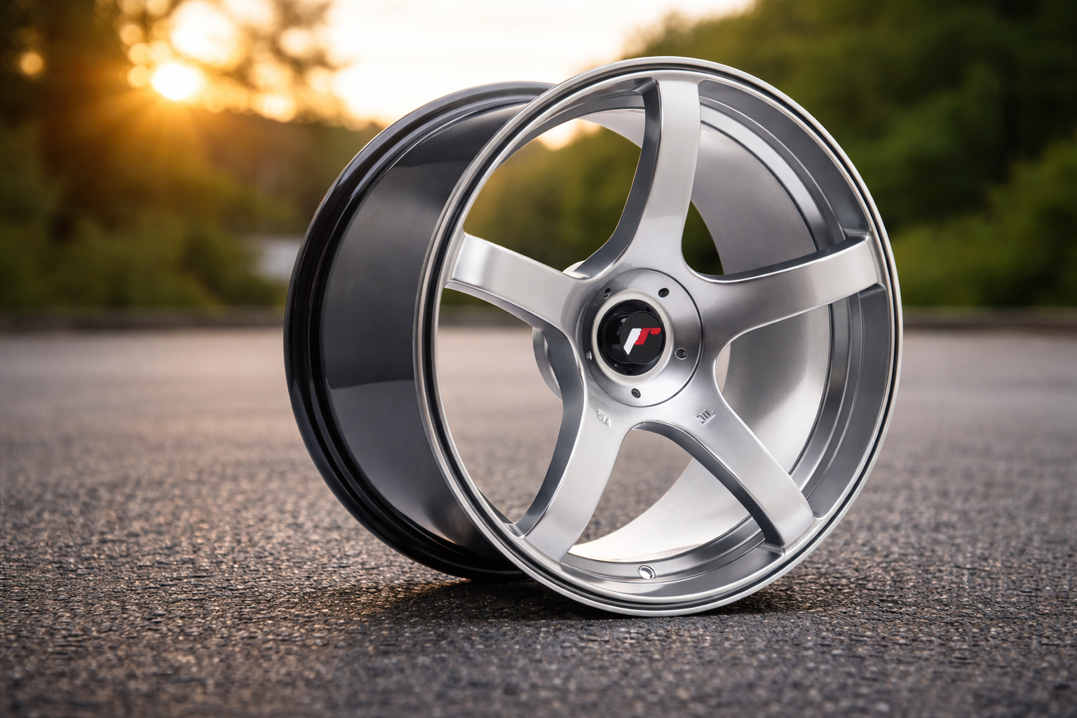 JR32 fälg i silver med fem ekrar fotograferad på asfalt i utomhusmiljö vid solnedgång