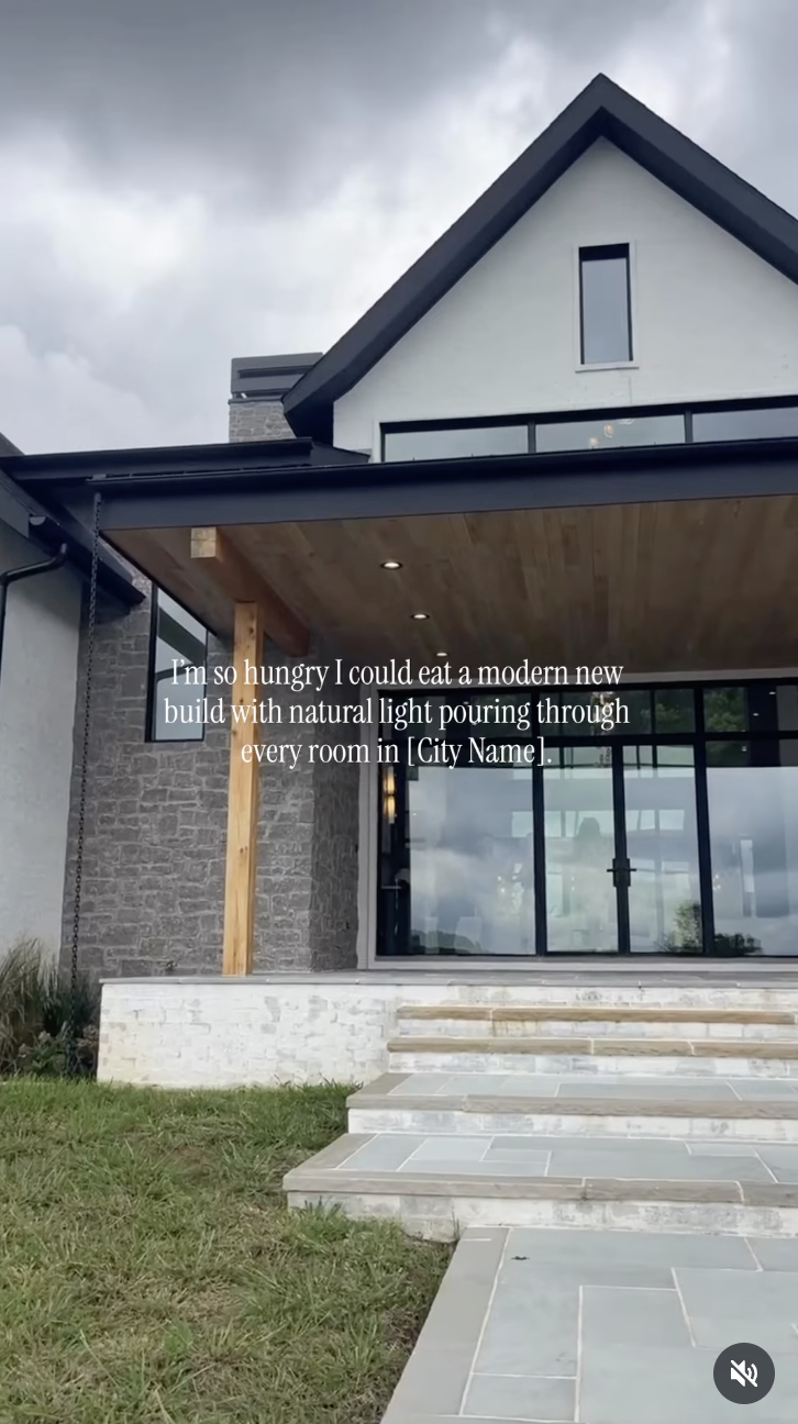  Modern farmhouse exterior with stone accents and large windows, overlaid with text: "I'm so hungry I could eat a modern new build with natural light pouring through every room in [City Name]."