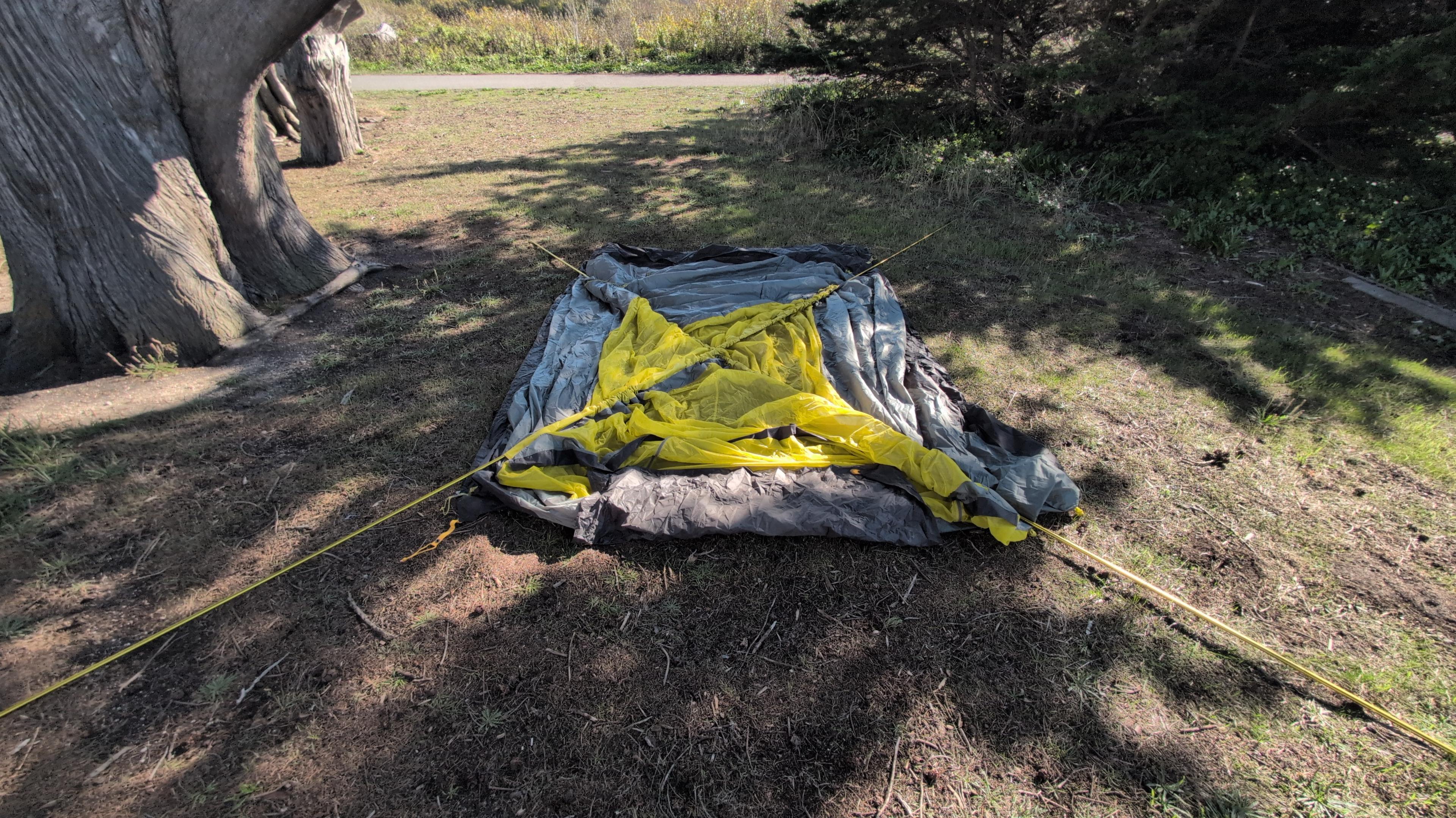 Two yellow tent poles threaded through sleeves in an X-pattern on the Wawona 6 tent body before raising