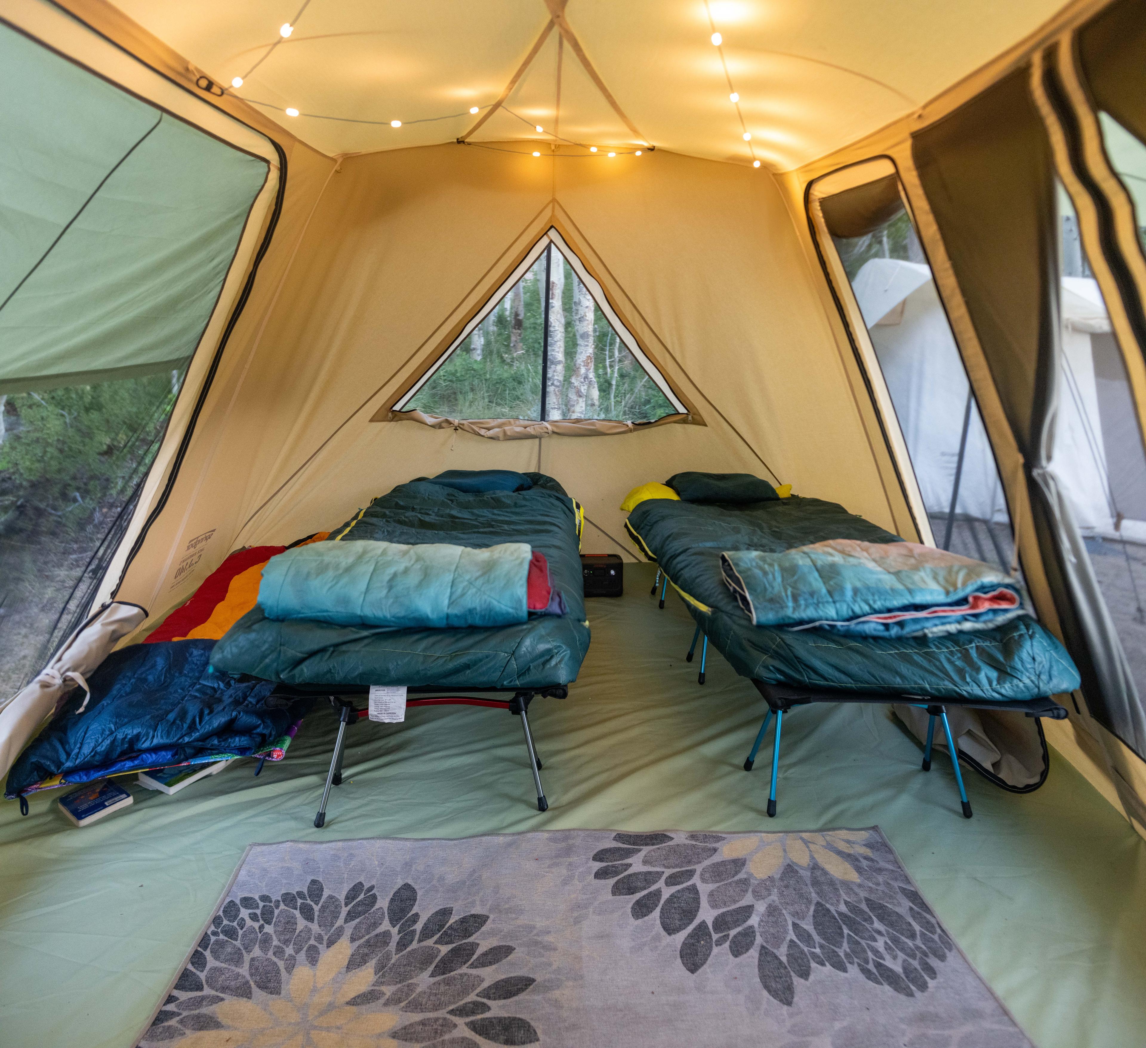 Camping sleep system setup with sleeping pad and sleeping bag inside a canvas tent