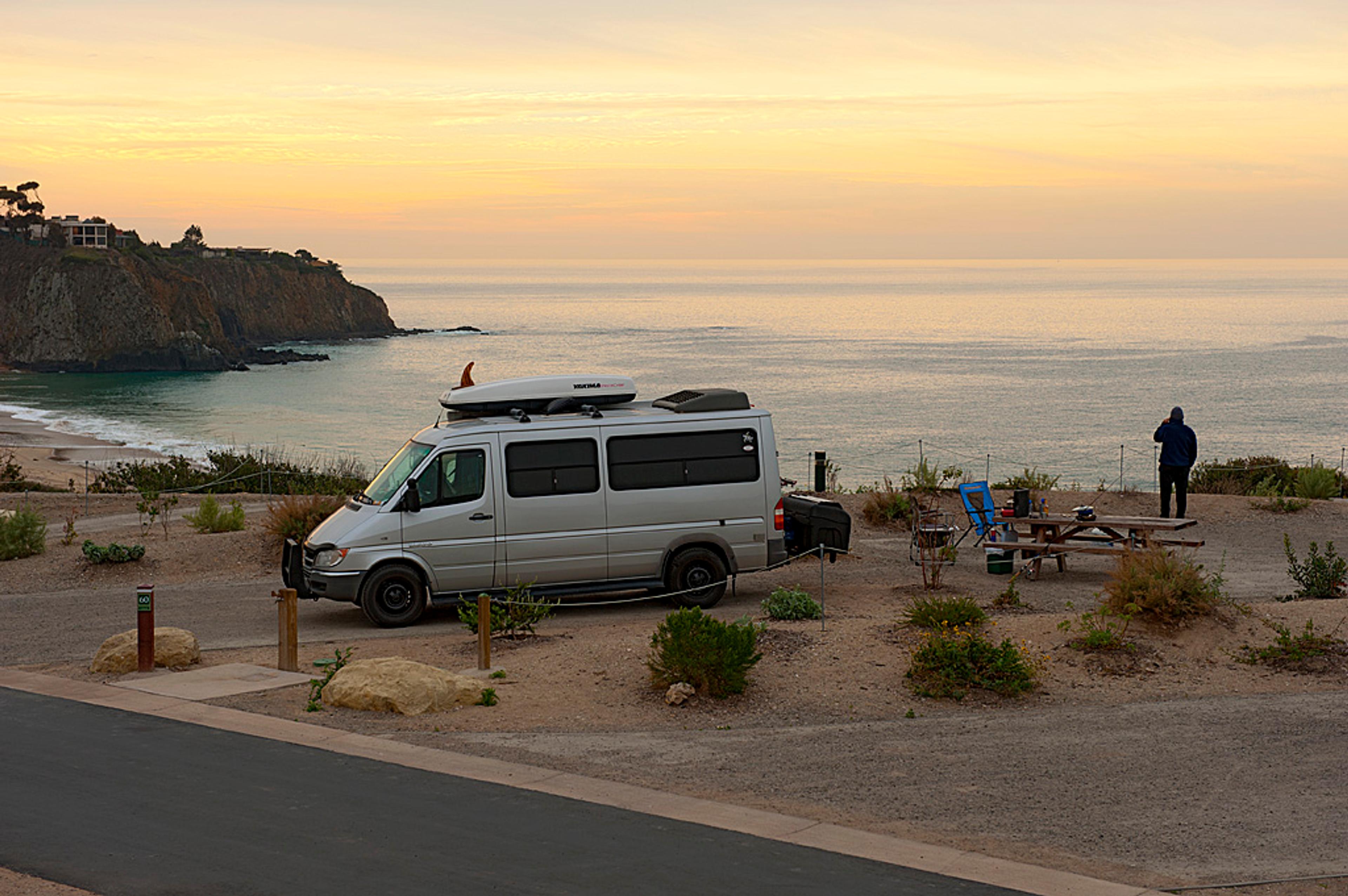 Camper van parked at a blufftop campsite at Crystal Cove State Park at sunset with ocean views Camper van parked at a blufftop campsite at Crystal Cove State Park at sunset with ocean views