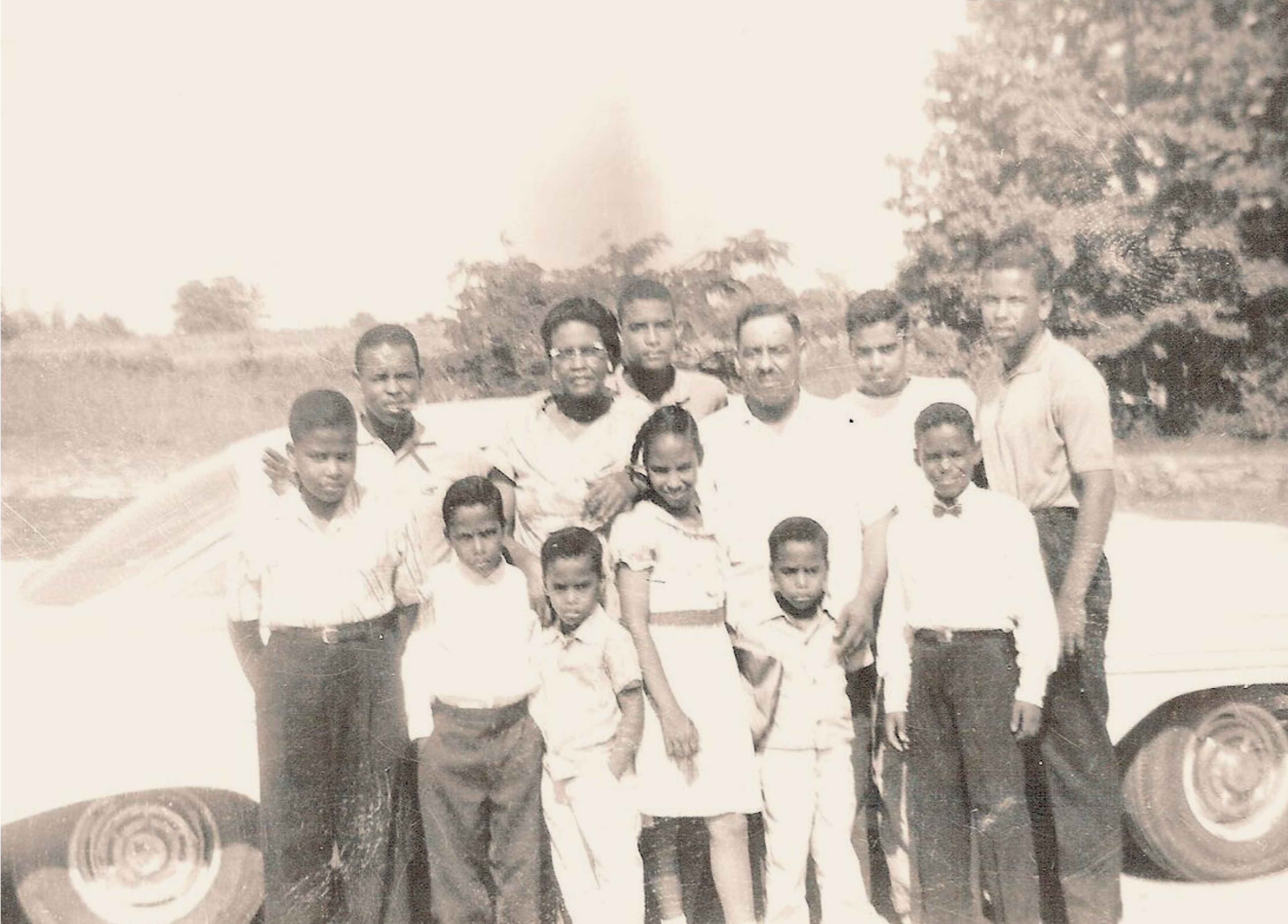 Historic family photo of a Black American family on a Memphis farm in the mid-20th century, showing Sally Steele's father as a young child seated in the front row with his parents and nine siblings