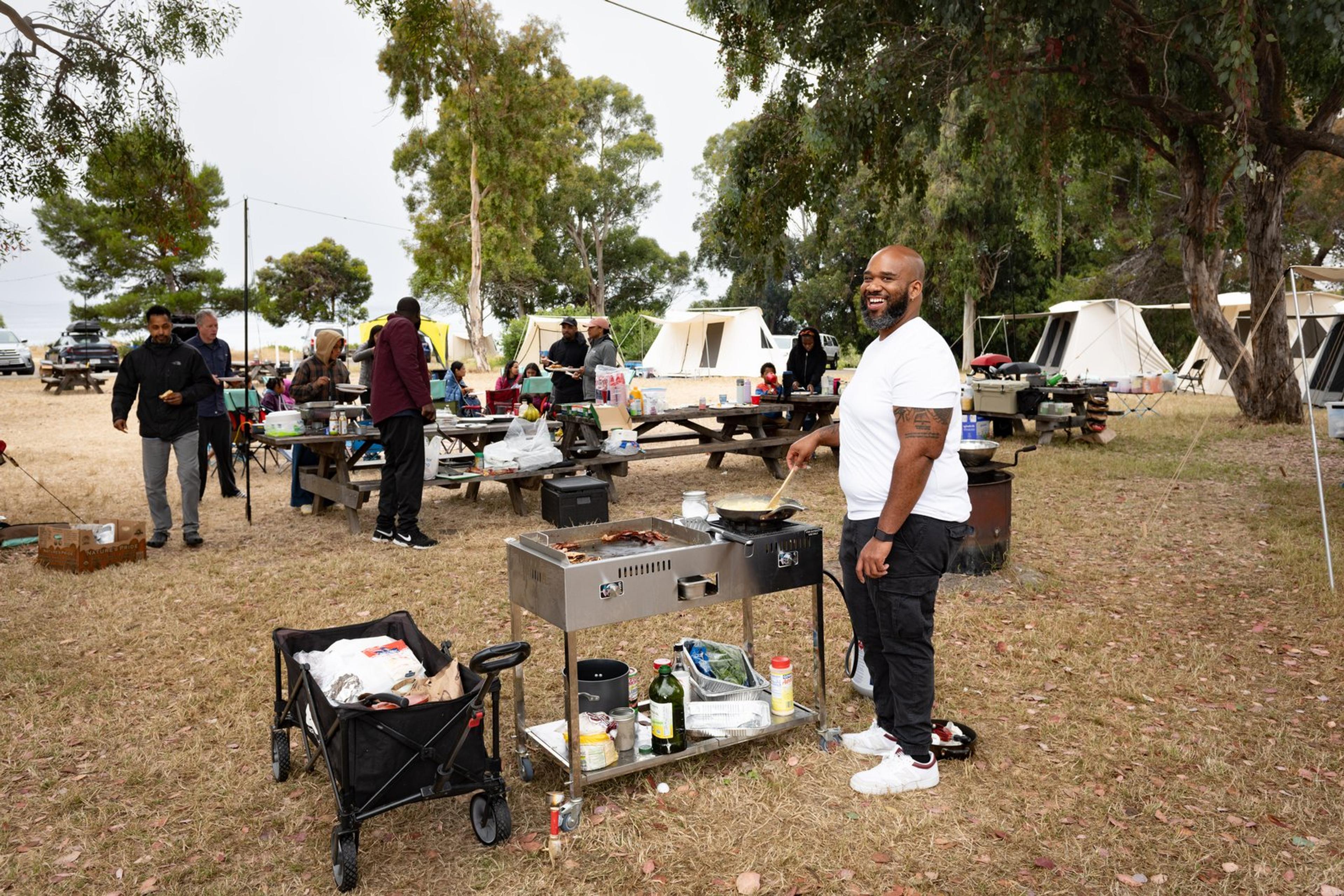 Camp kitchen setup with family cooking outdoors at a glamping campsite Camp kitchen setup with family cooking outdoors at a glamping campsite