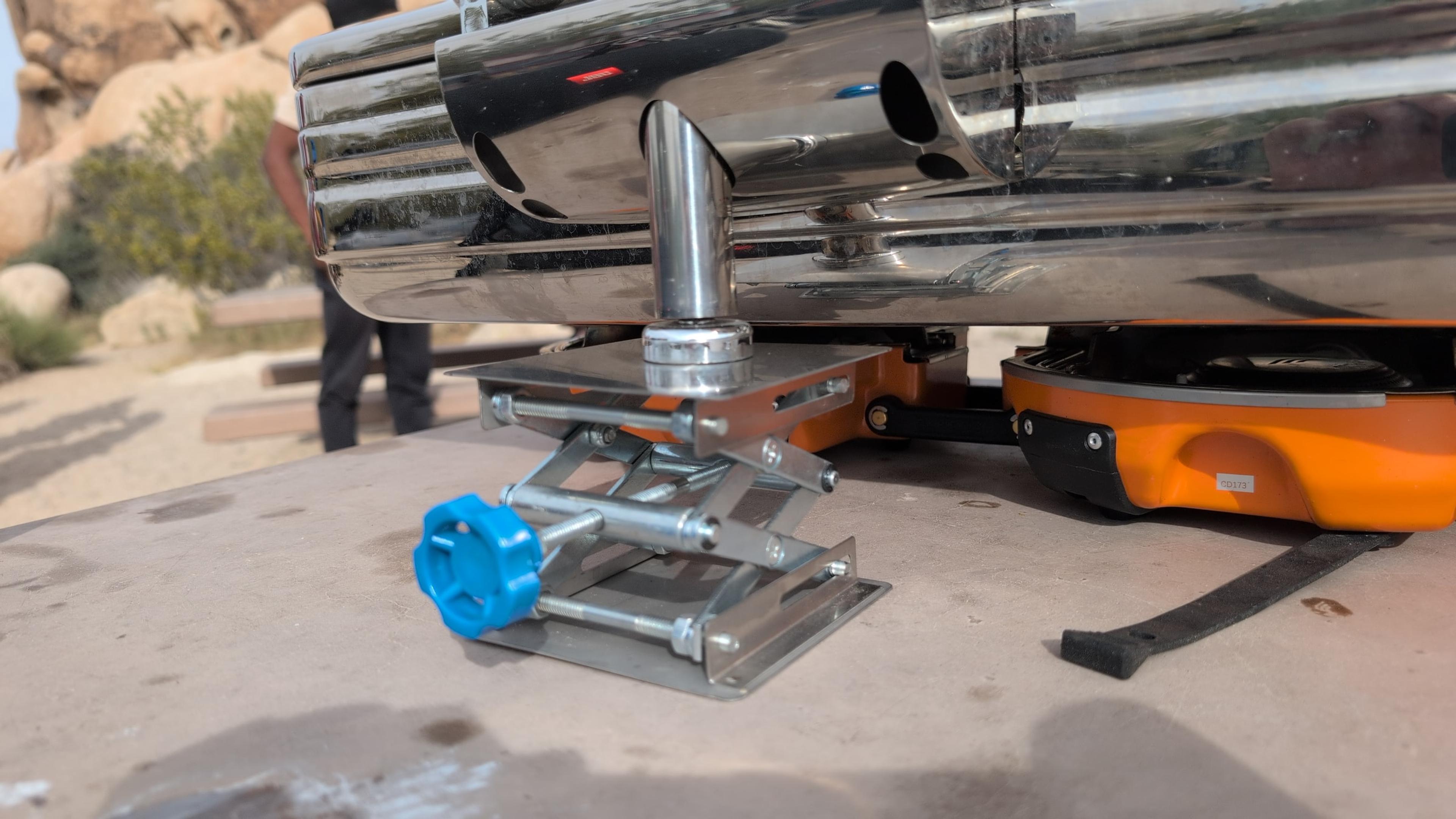 Stainless steel lab jack stand with blue adjustment knob supporting the back edge of a chafing dish over a Jetboil burner Stainless steel lab jack stand with blue adjustment knob supporting the back edge of a chafing dish over a Jetboil burner