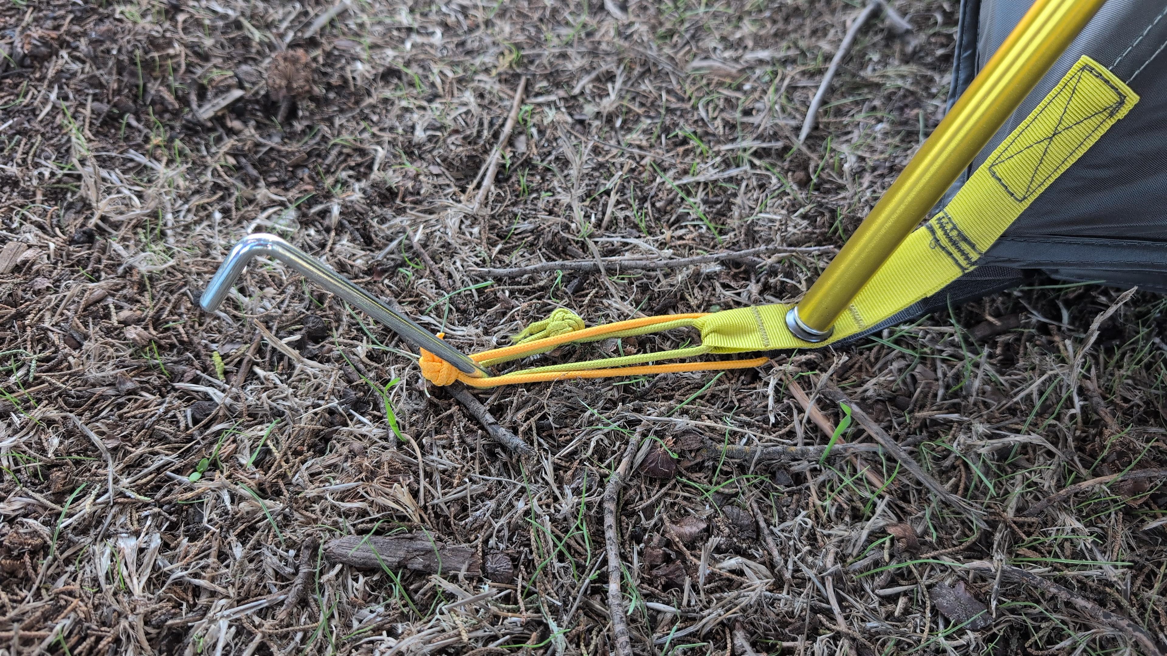 Tent stake driven at a 45-degree angle at the corner of a Wawona 8 tent