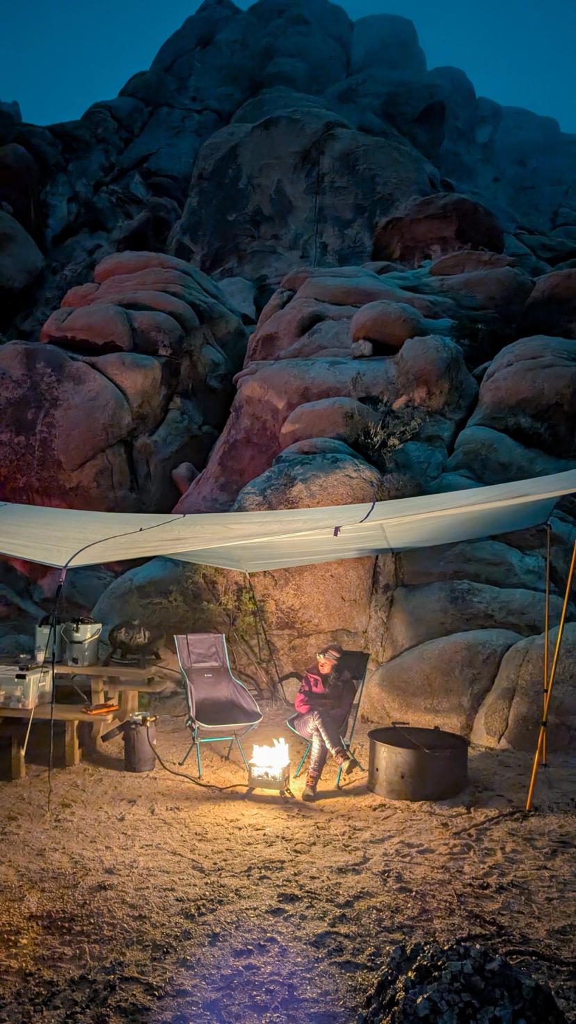 Tarp shelter setup at a Joshua Tree campsite with chairs underneath, desert landscape in background Tarp shelter setup at a Joshua Tree campsite with chairs underneath, desert landscape in background