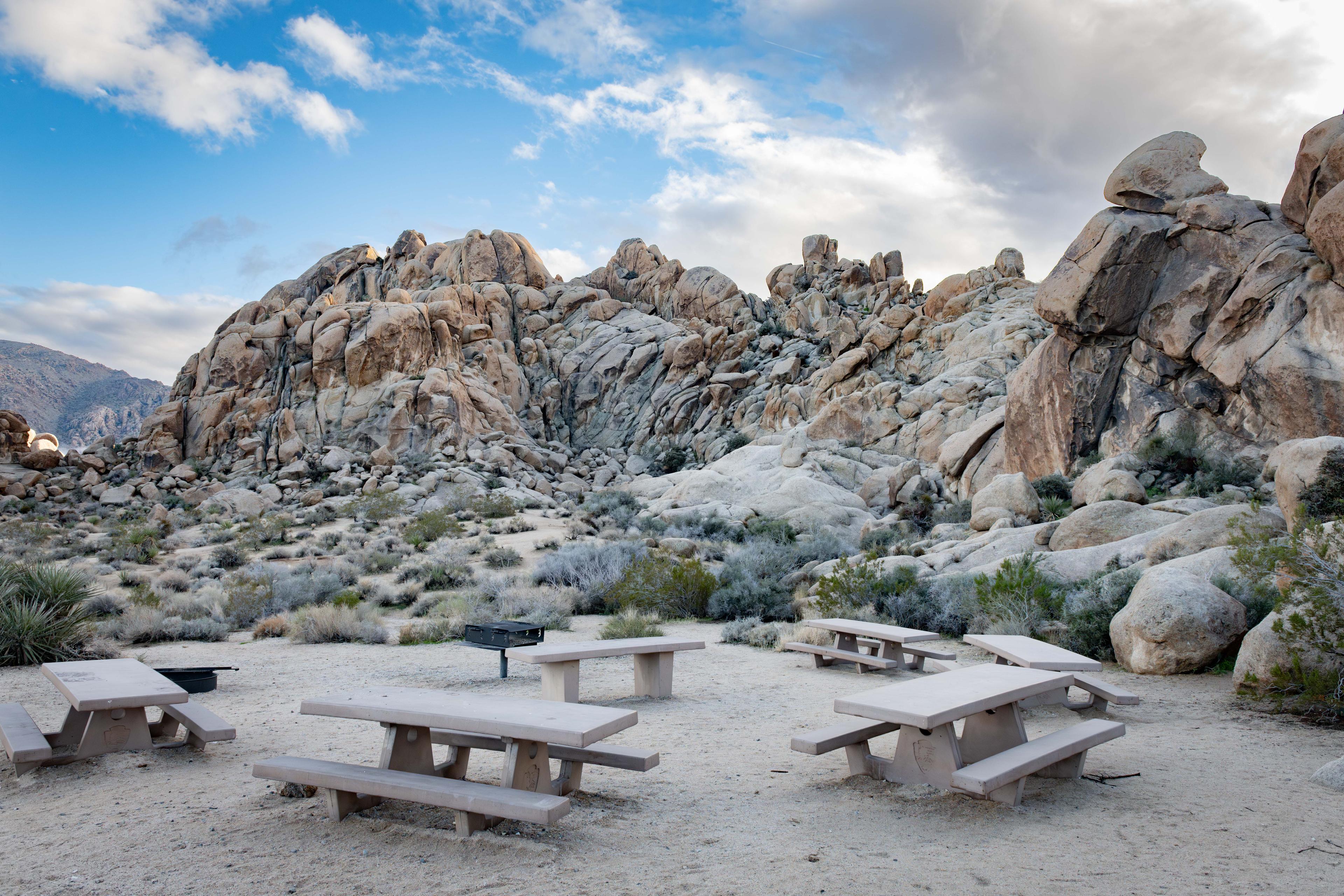 Joshua Tree campsite surrounded by massive boulder formations under a blue desert sky