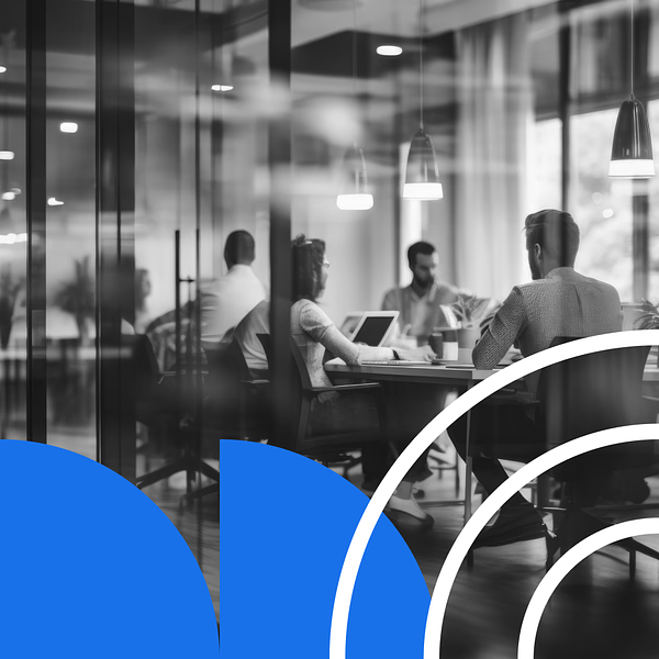 Individuals sitting at a conference table discussing the benefits of an AI-connected CMS