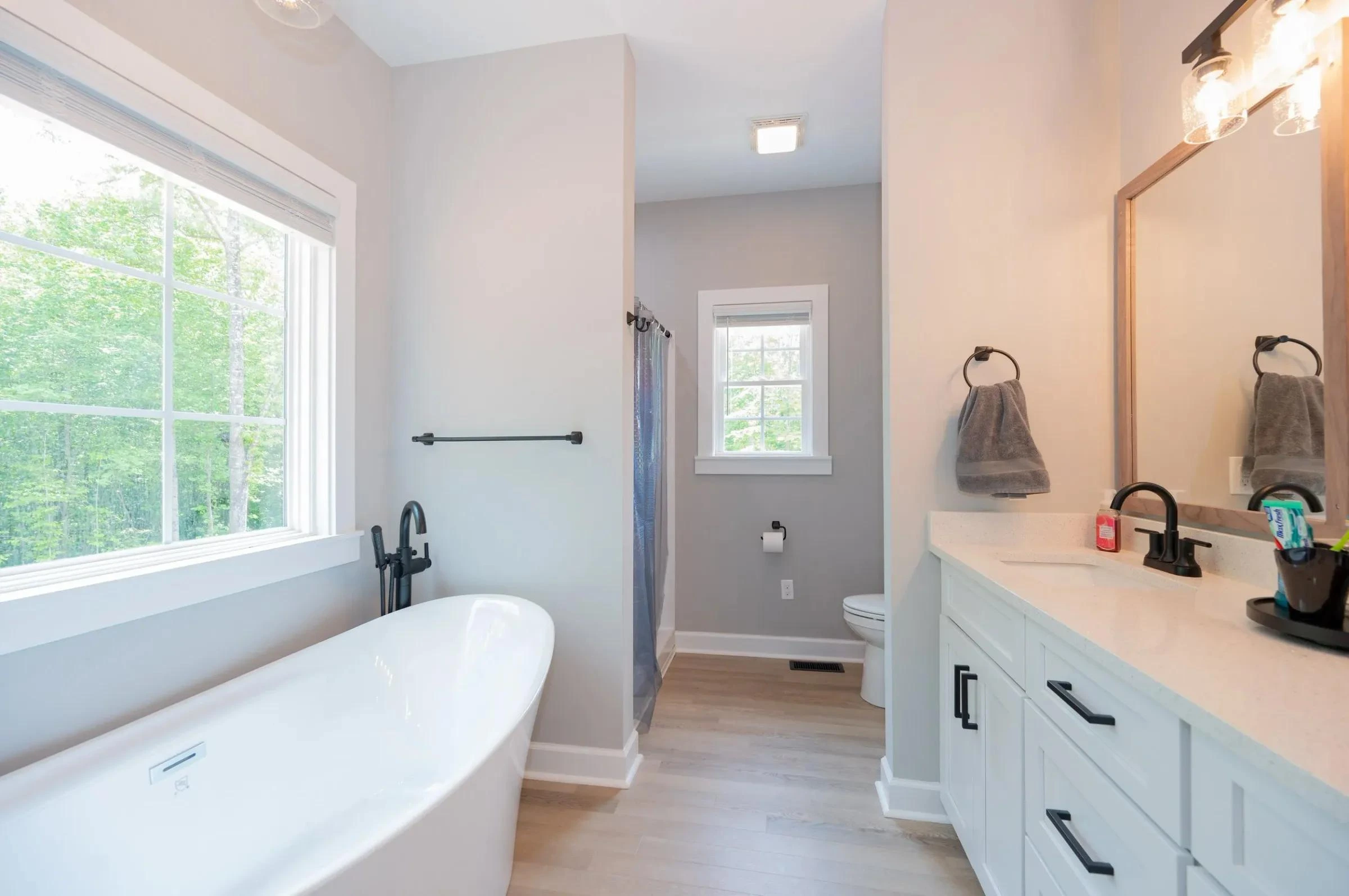 Bathroom with a freestanding tub beside a large window
