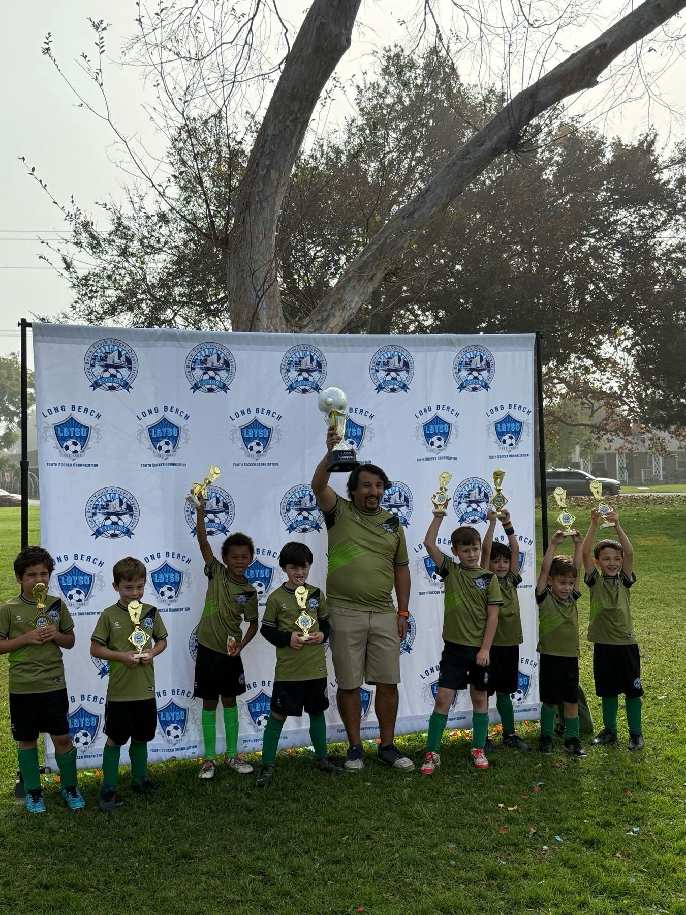 The Boys U8 championship team posing with trophies.