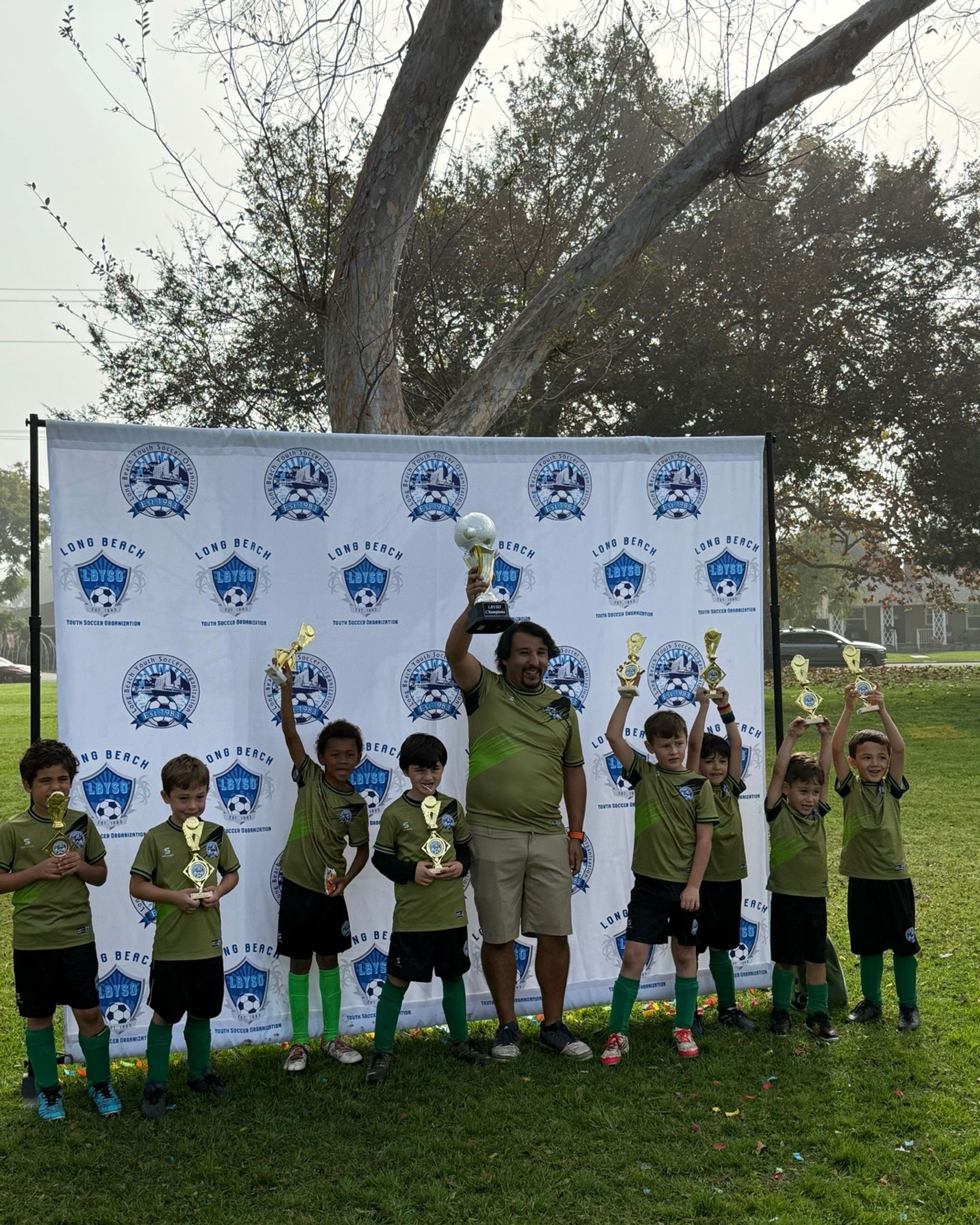 The Boys U8 championship team posing with trophies.