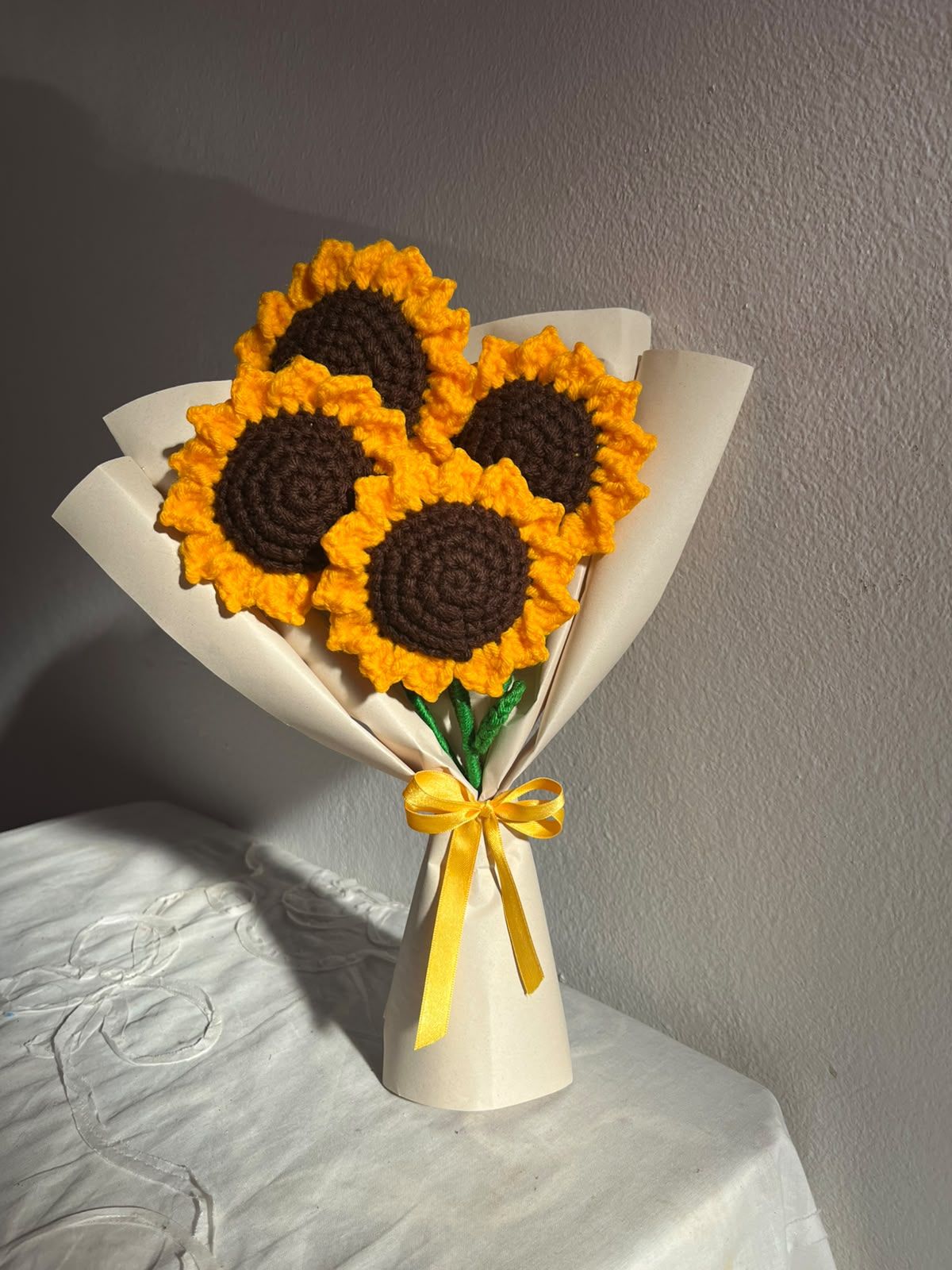 Ramo de Girasol grande tejido a crochet con pétalos amarillos, sobre una mesa