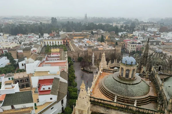 Vista panorámica de la Catedral de Sevilla y la Giralda al atardecer, con el casco histórico iluminado