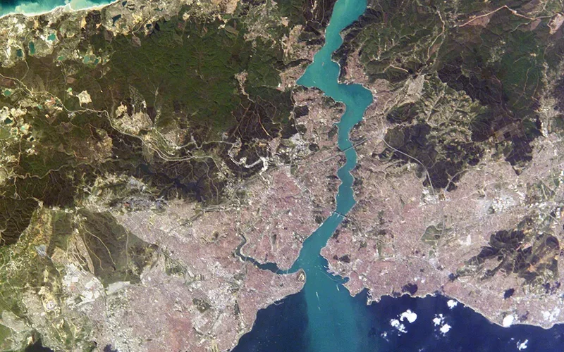 Vista satelital del Estrecho del Bósforo, con aguas turquesas separando las costas europeas y asiáticas de Estambul, flanqueadas por colinas verdes y