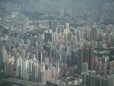 Vista panorámica nocturna del puerto Victoria de Hong Kong con rascacielos iluminados reflejados en el agua