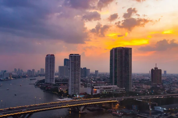 Vista panorámica del skyline de Bangkok con templos dorados y rascacielos modernos al atardecer