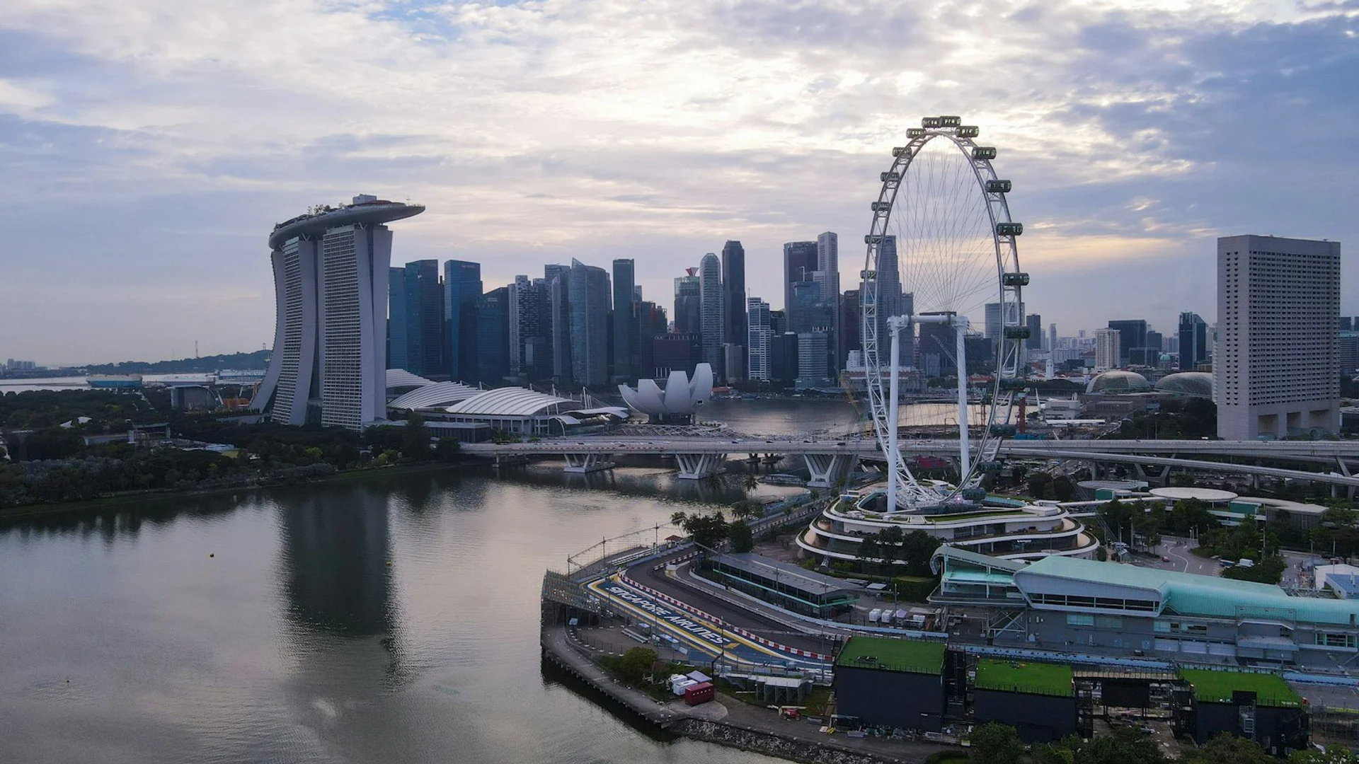Contraste entre templos tradicionales asiáticos y modernos rascacielos iluminados al atardecer