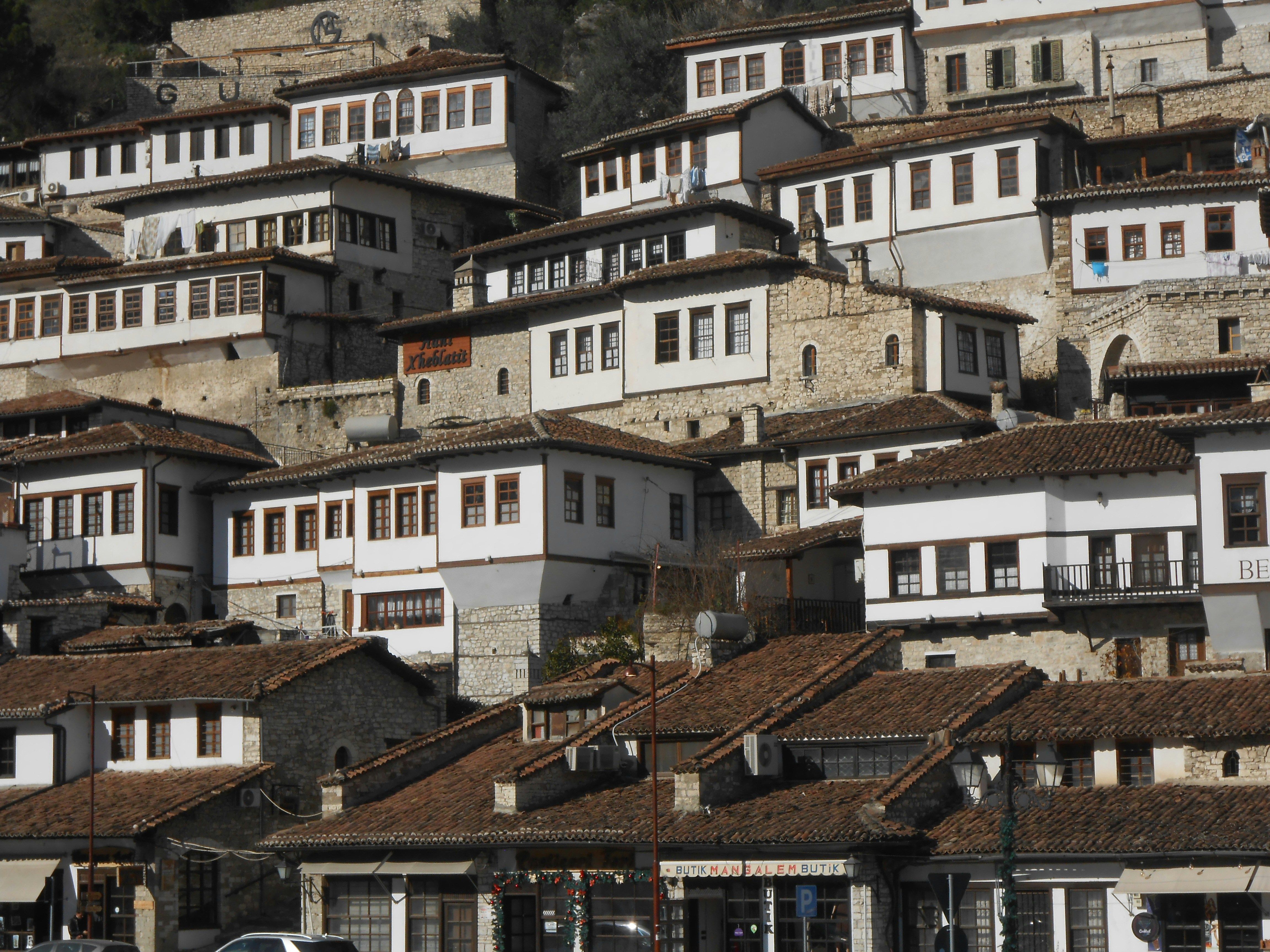 Casas tradicionales de piedra y techos de teja roja escalonadas en una ladera.