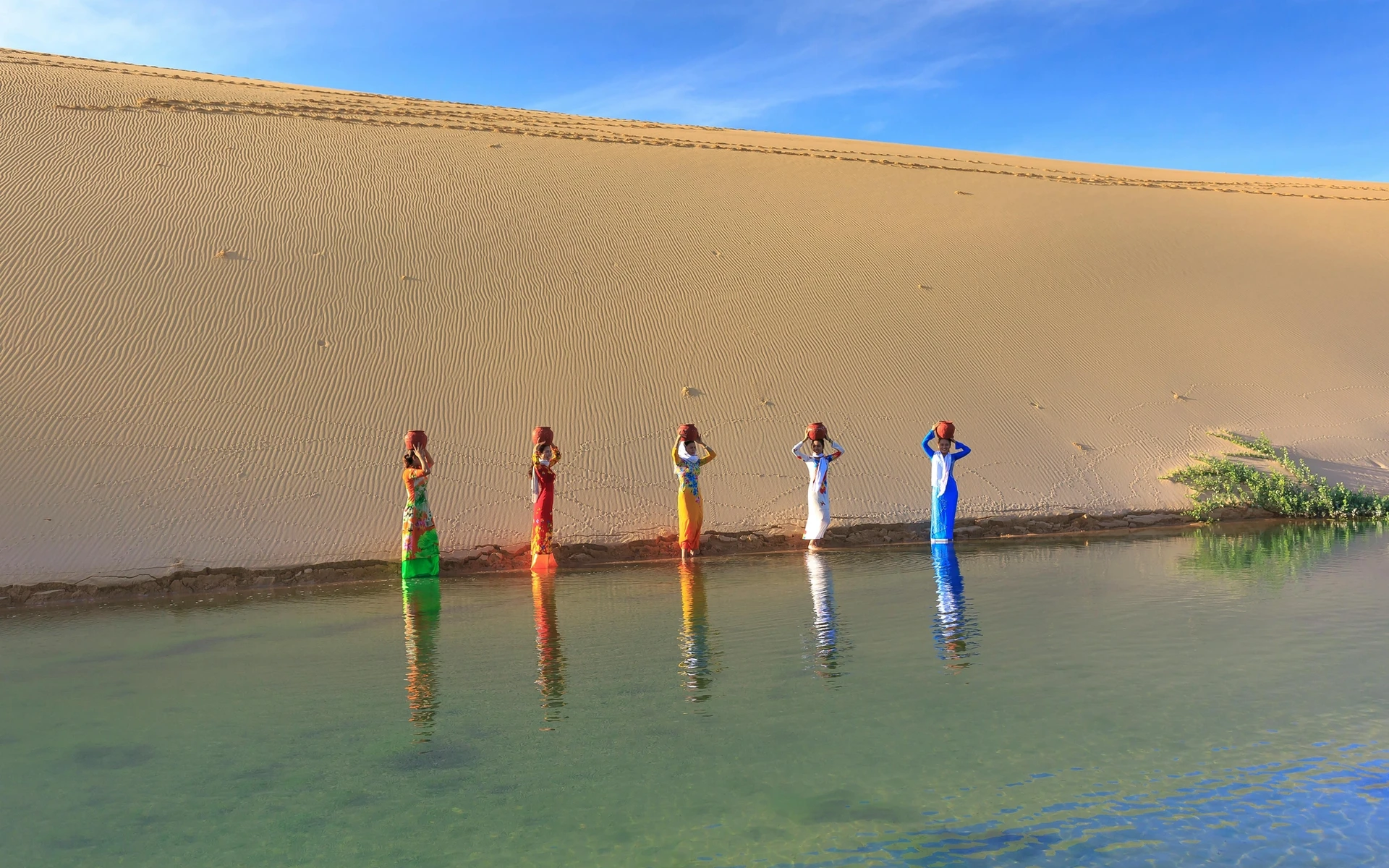 Mujeres cham en las dunas de Mũi Né, Vietnam. El pueblo cham fue navegante y comerciante; hoy habitan entre el desierto y el mar.