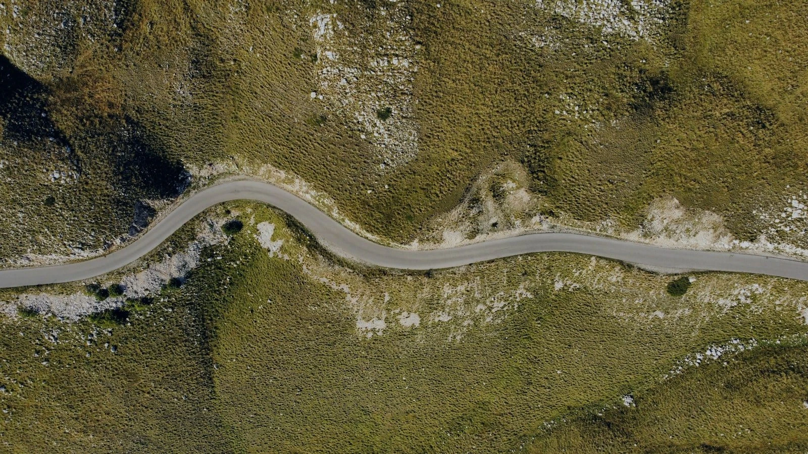 an aerial view of a winding road in the mountains