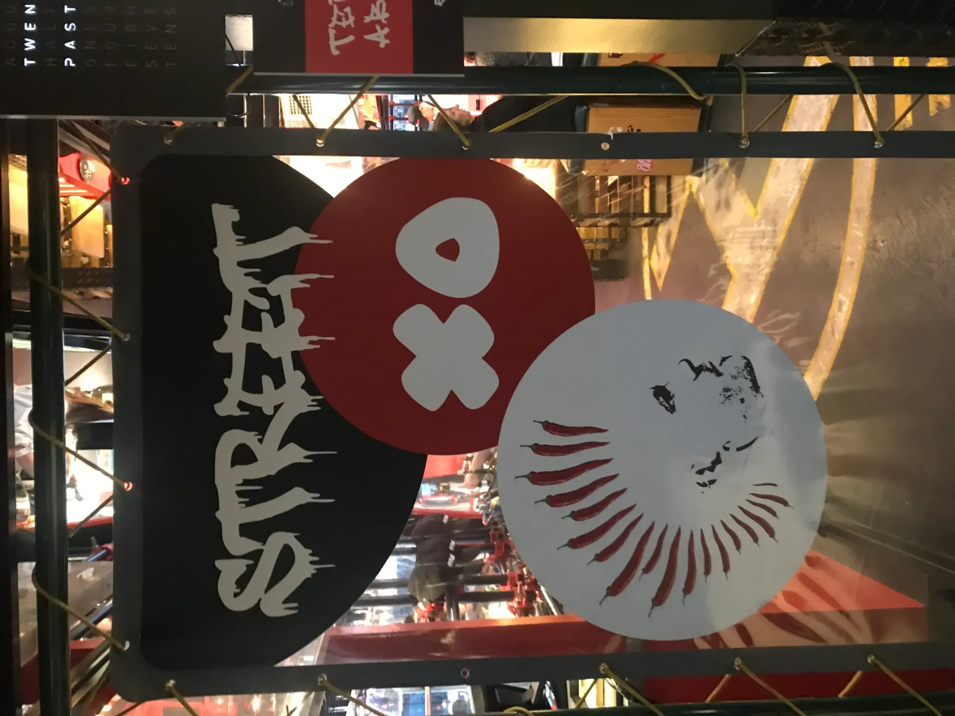 Vista de la entrada del StreetXo Madrid con carteles negros y rojos del logo, círculos con "Xo" en blanco y diseños decorativos