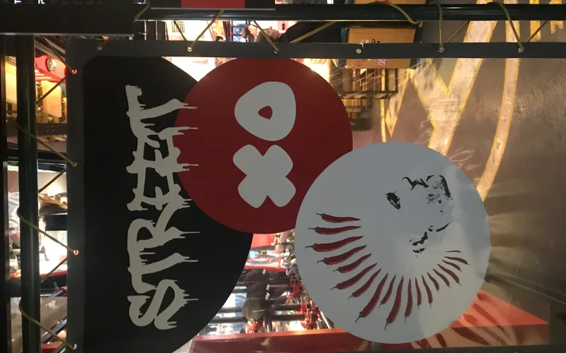 Vista de la entrada del StreetXo Madrid con carteles negros y rojos del logo, círculos con "Xo" en blanco y diseños decorativos