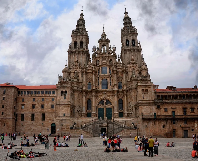 Fachada del Obradoiro de la catedral de Santiago con gente sentada en la plaza