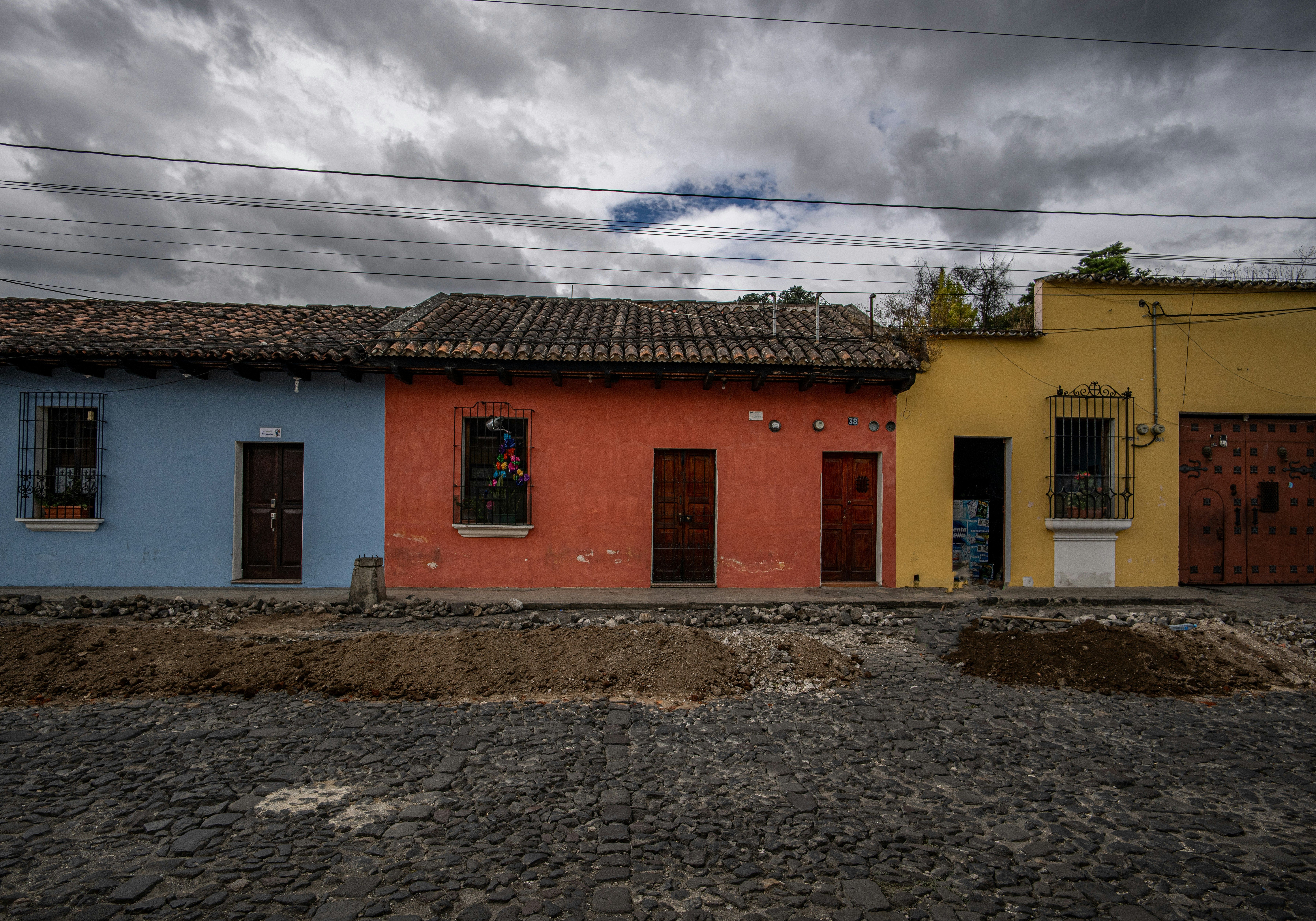 Casona indiana de piedra con balcones y tejado de pizarra, rodeada de vegetación.