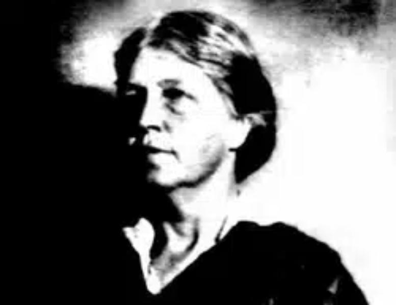 Retrato en blanco y negro de Neltje Blanchan, mujer de cabello claro recogido, con vestido oscuro de cuello blanco y mirada seria de perfil