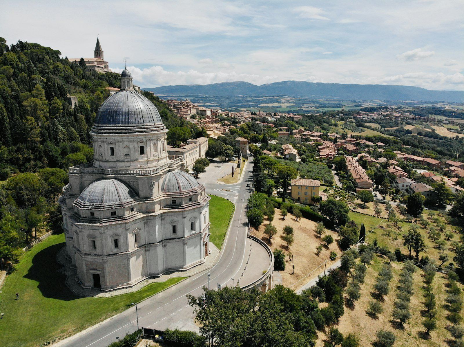 a large building with a dome on top surrounded by trees