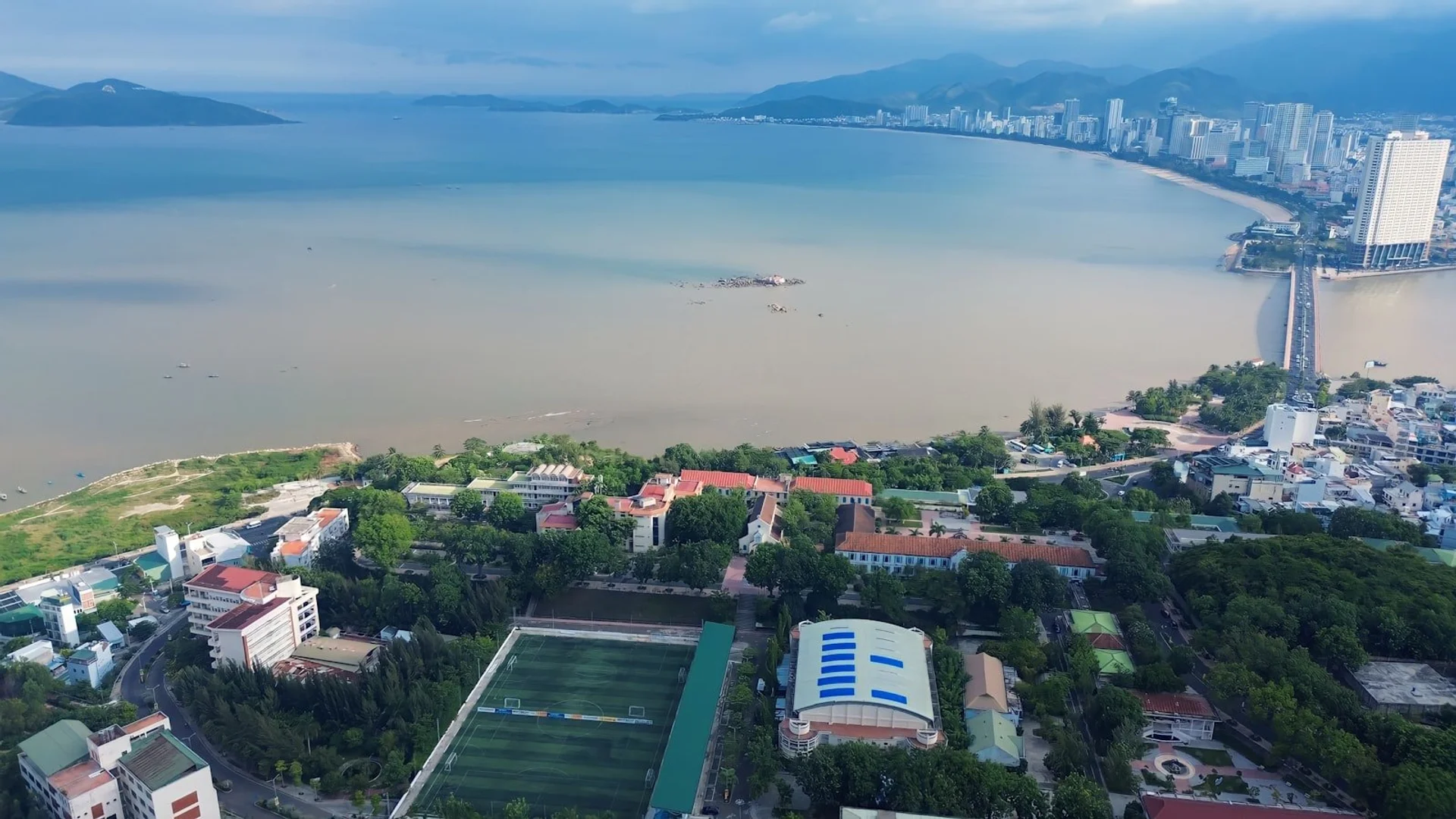 Vista aérea playa Nha Trang con torres Cham y barcos pesqueros