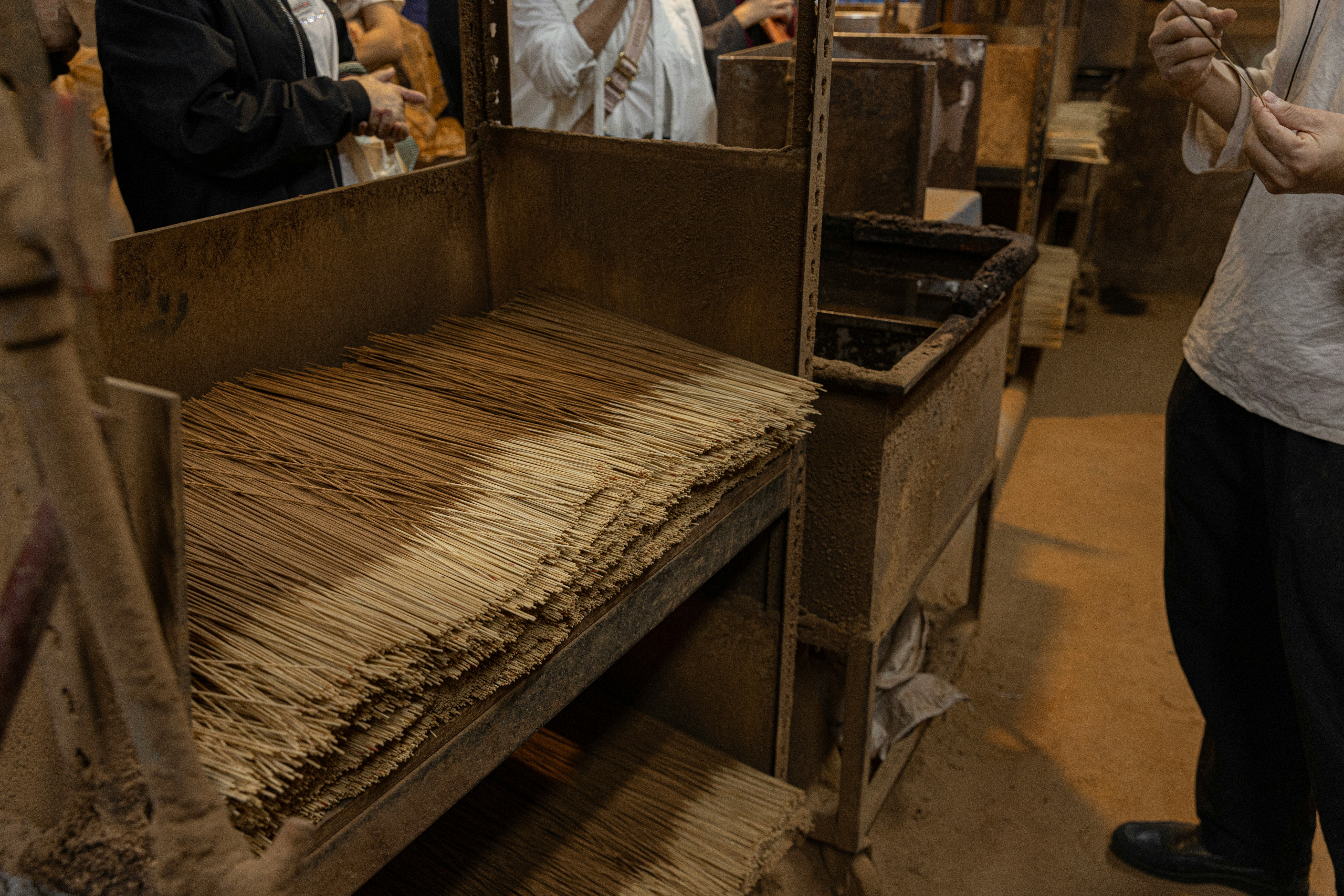 Hojas de papel washi secándose en estantes de madera en un taller artesanal.