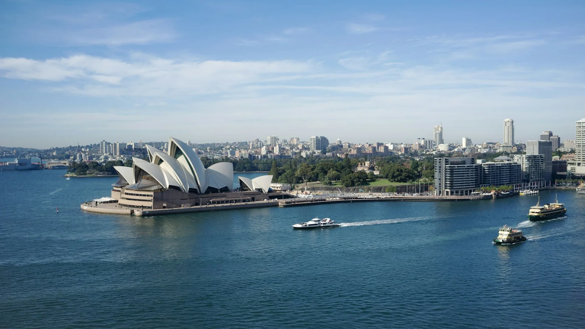 Aerial view of Sydney Harbour featuring the Opera House and Harbour Bridge at sunset