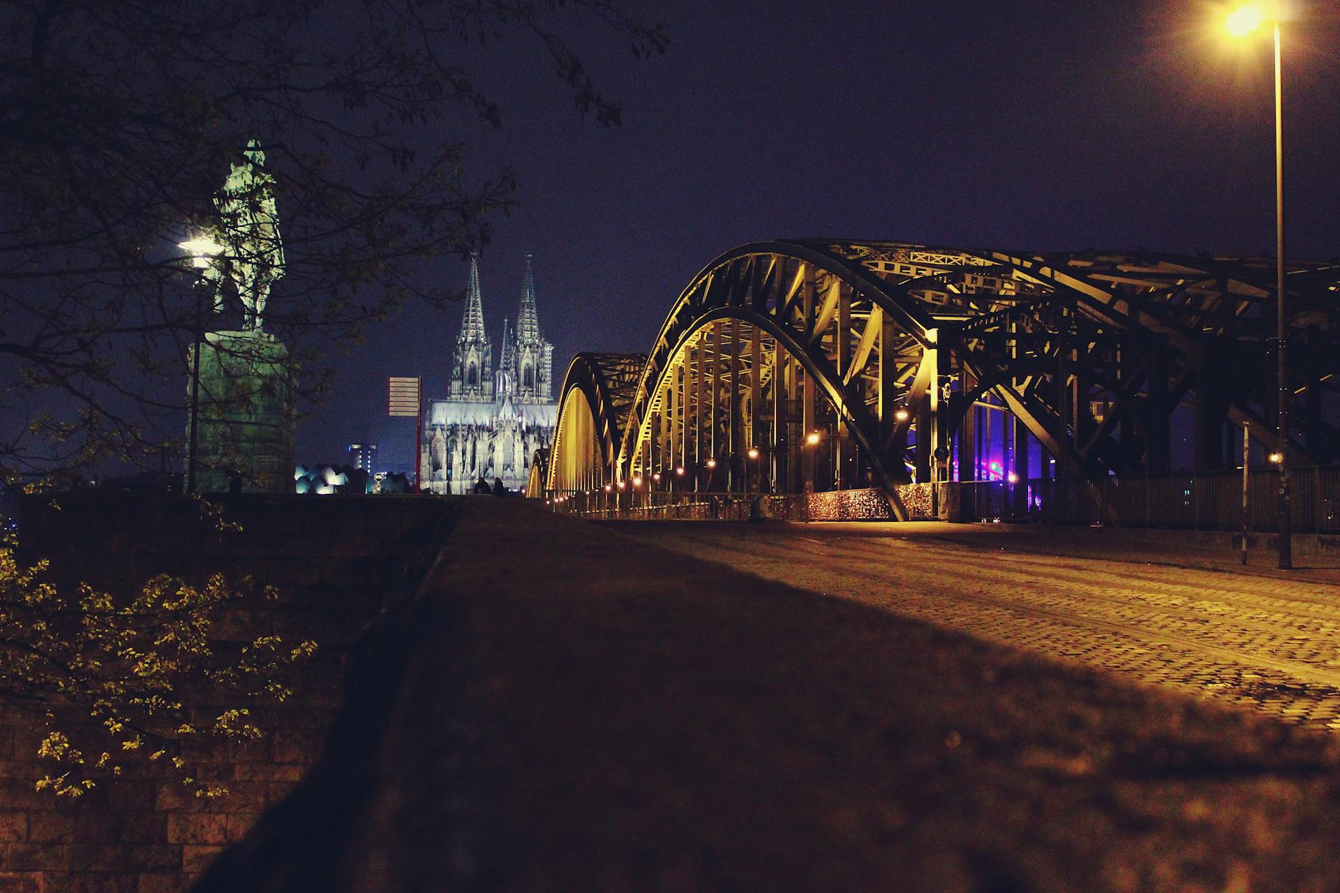 La imponente Catedral de Colonia se eleva sobre el río Rin, con vistas al puente Hohenzollern en un día soleado de verano