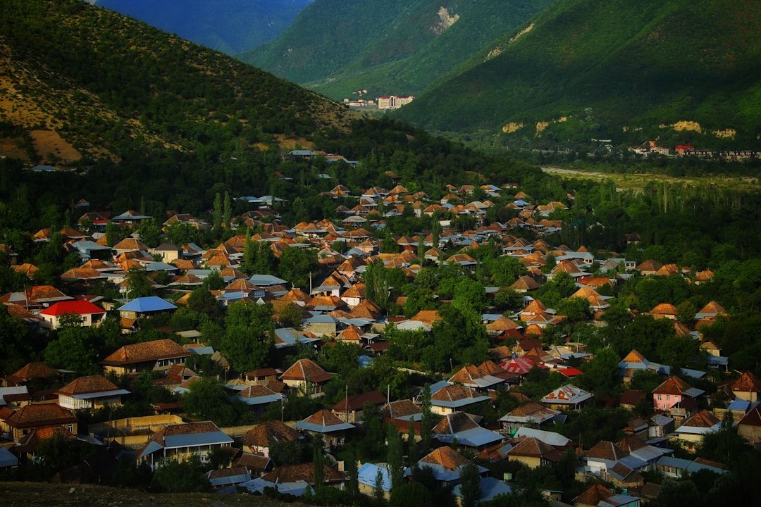 Vista panorámica de Sheki, con casas de techos rojos y coloridos en un valle verde rodeado de montañas