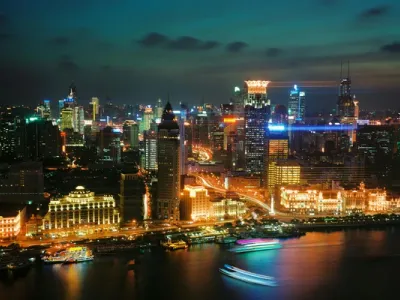 Vista nocturna de la skyline de Shanghái con rascacielos iluminados en Pudong y el Bund junto al río Huangpu