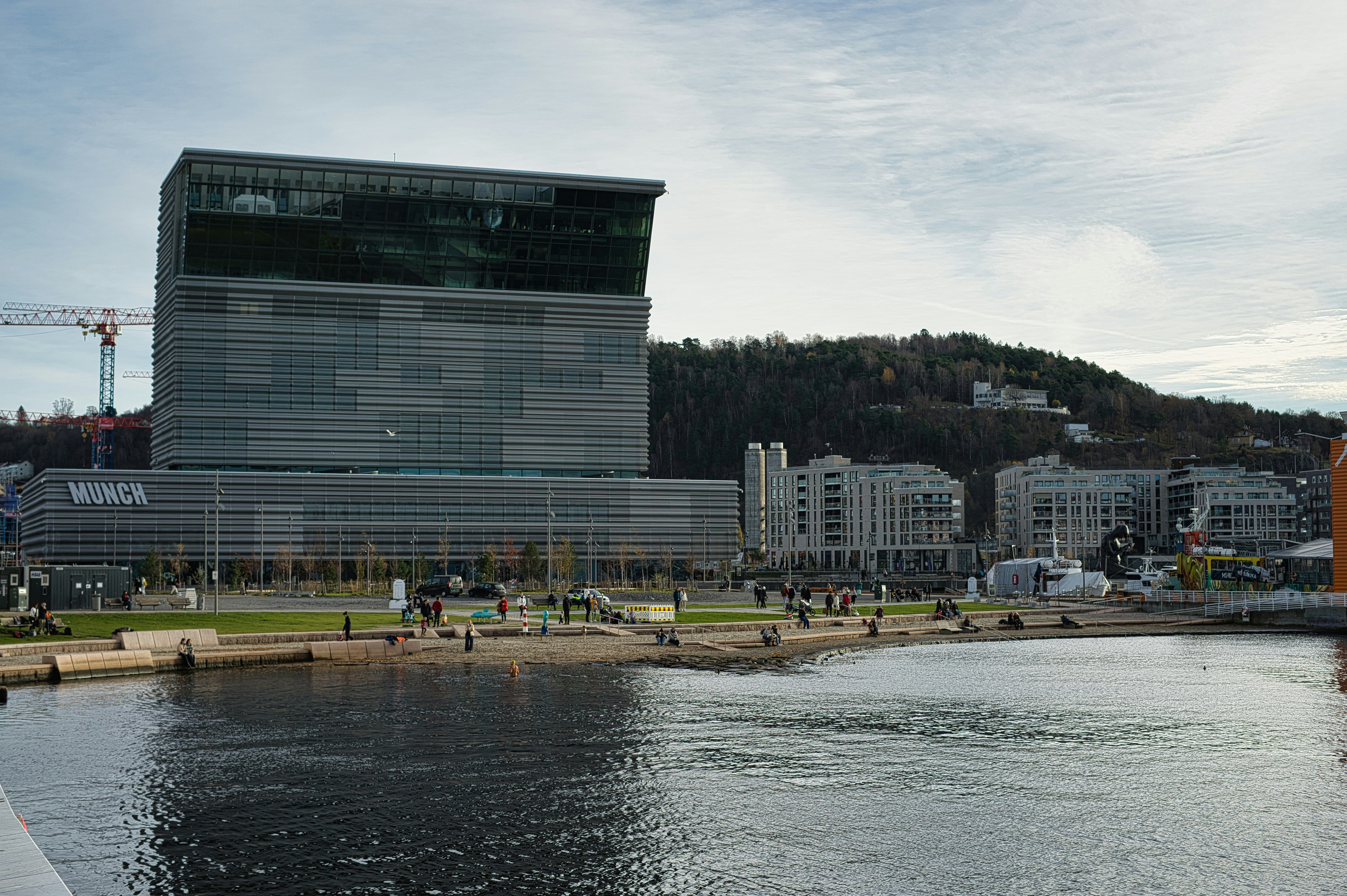 Vista exterior del moderno edificio del Museo Munch en Oslo, junto a un cuerpo de agua.