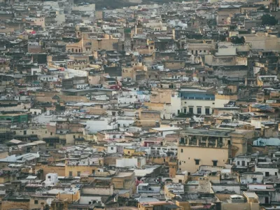 Vista panorámica de la medina de Fes con edificios apiñados en tonos arena y ocres, techos planos y colinas urbanas