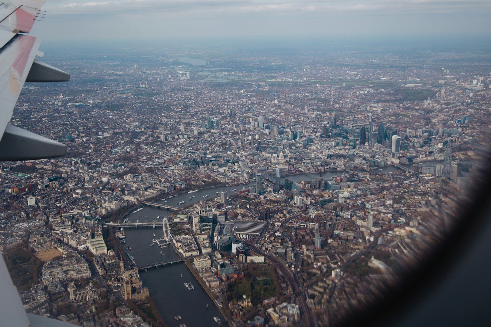 Vista aérea de Londres desde un avión, con el río Támesis, el London Eye y edificios extendiéndose bajo el ala