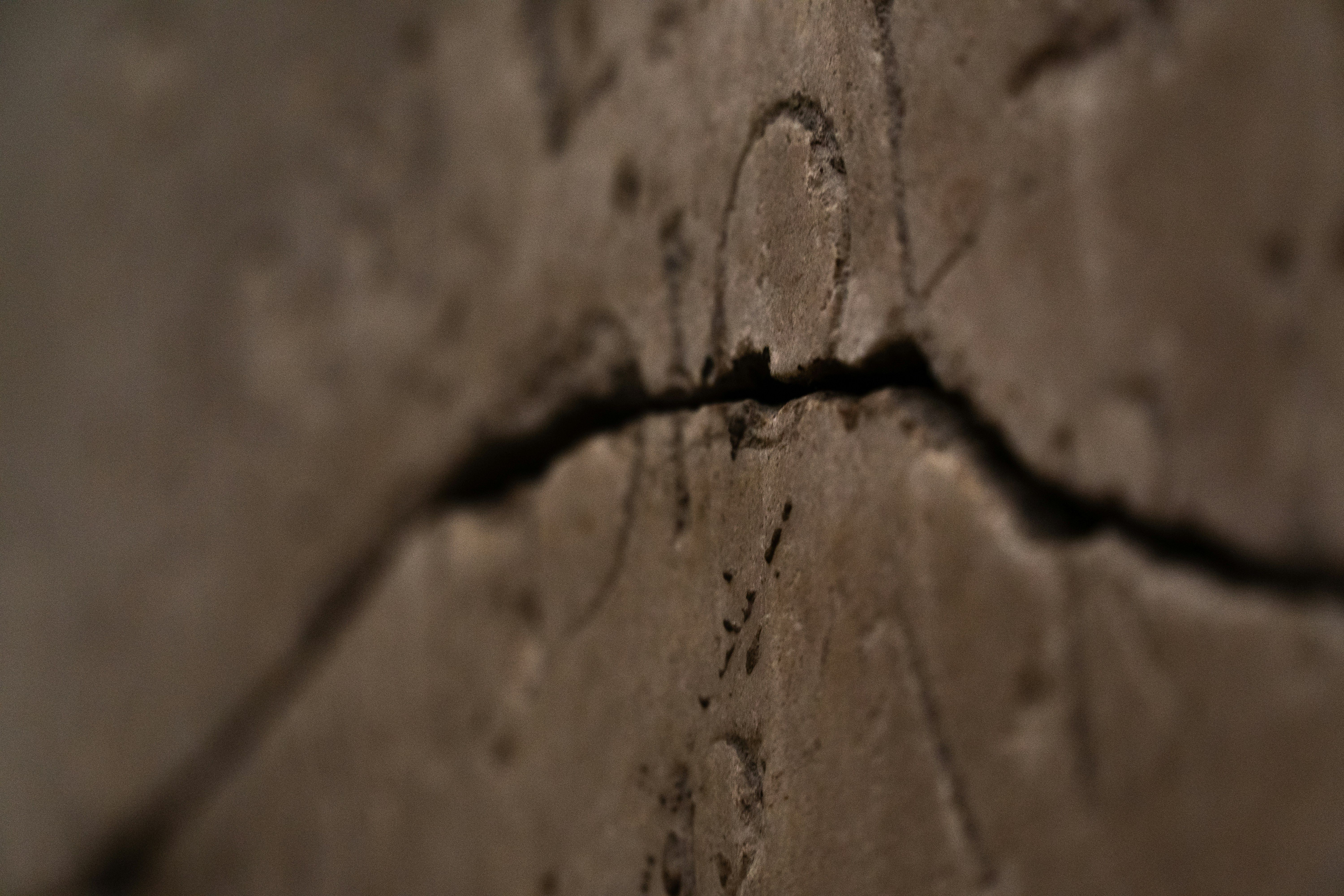 Primer plano de una grieta oscura y profunda en una superficie de cerámica o piedra clara.