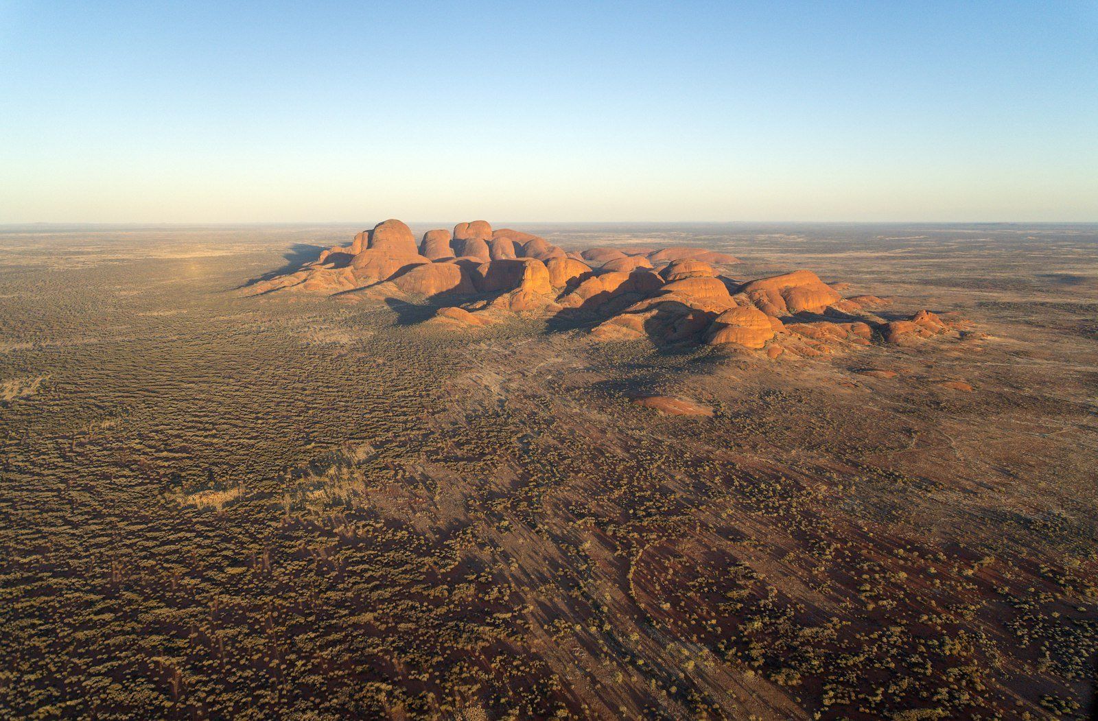 Rocky desert landscape with rounded rock formations at sunset.