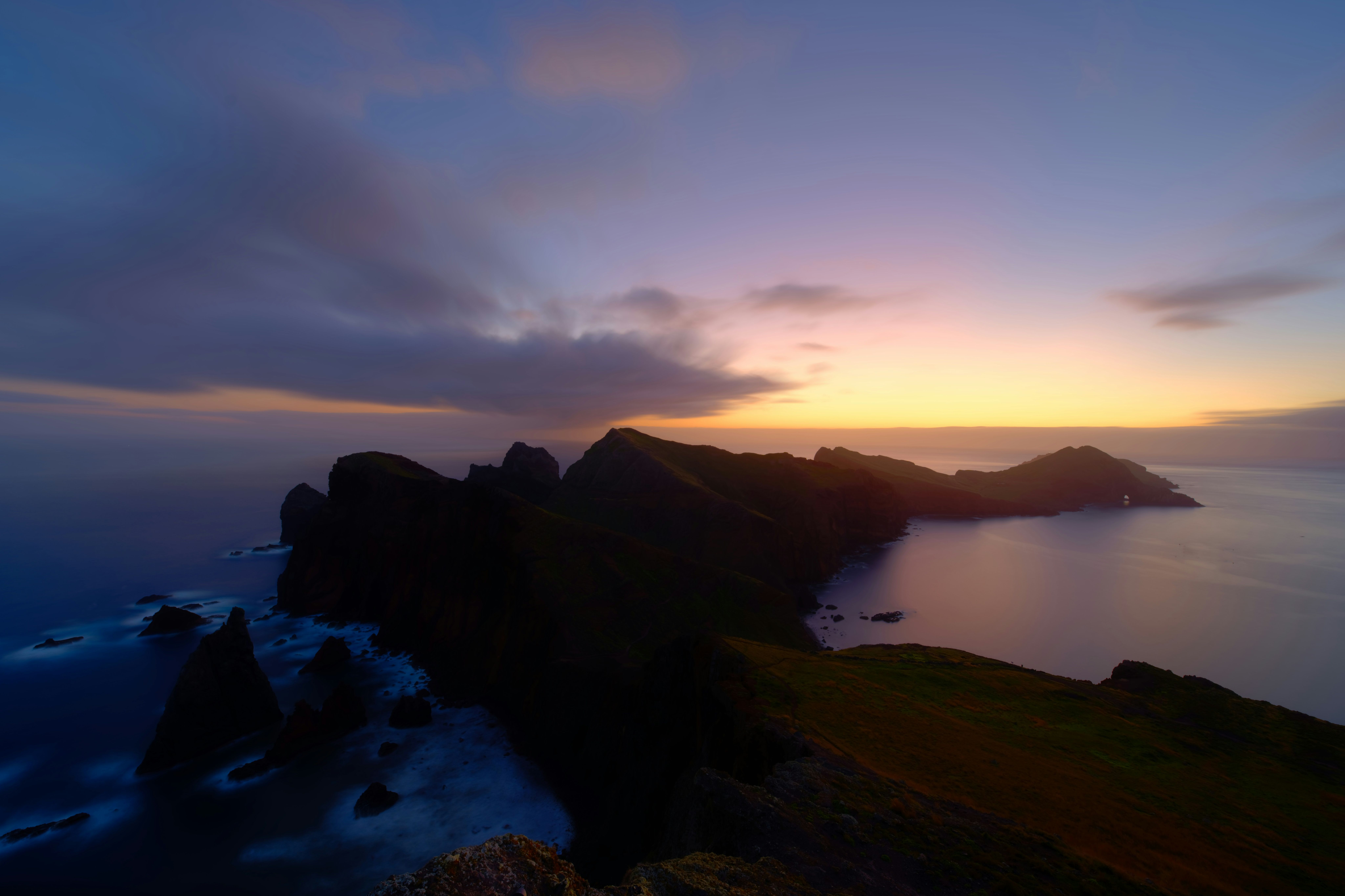 Vista aérea de acantilados oscuros y escarpados en la costa de Madeira al amanecer.