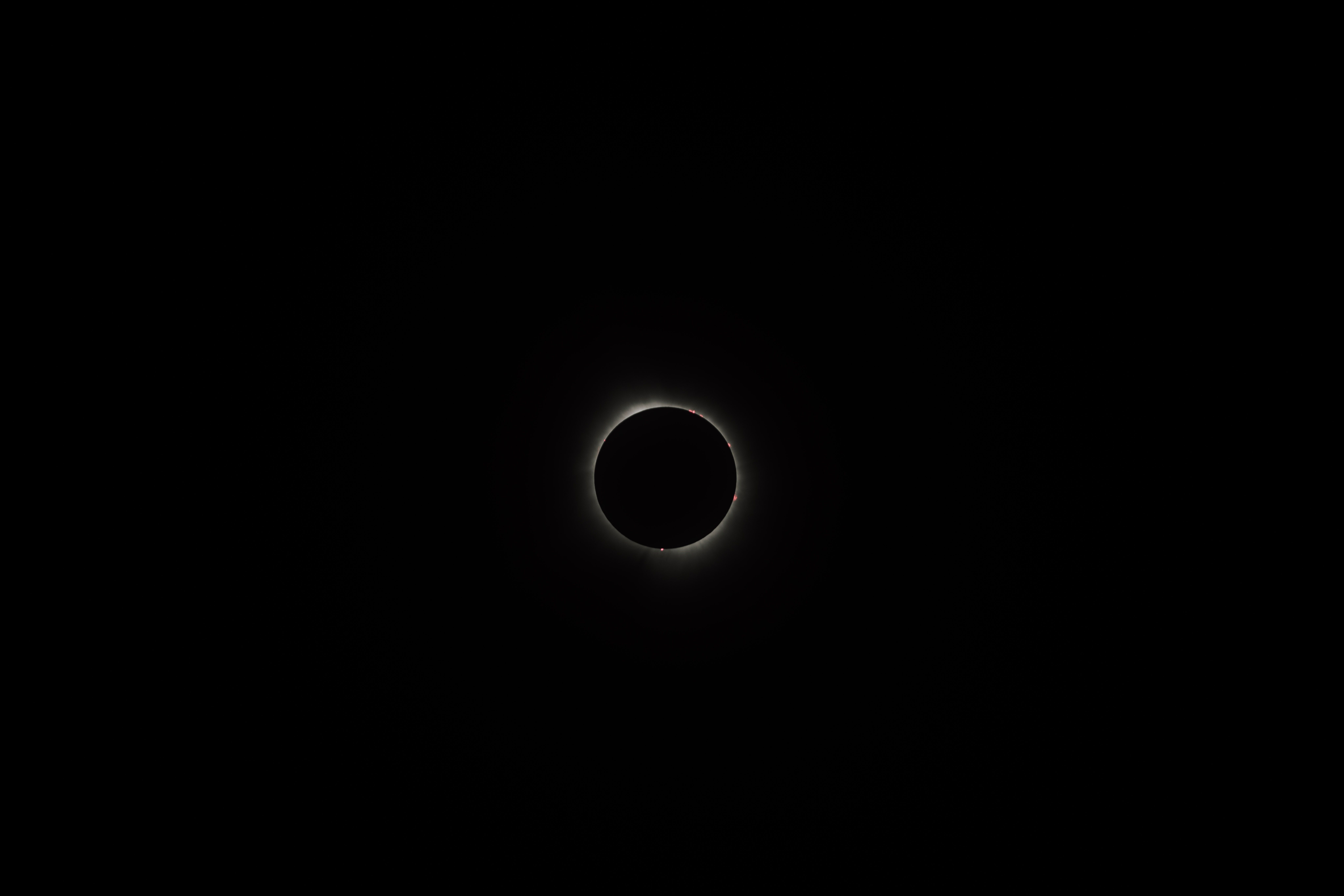 Un eclipse solar total con la corona solar visible alrededor del disco oscuro de la Luna.
