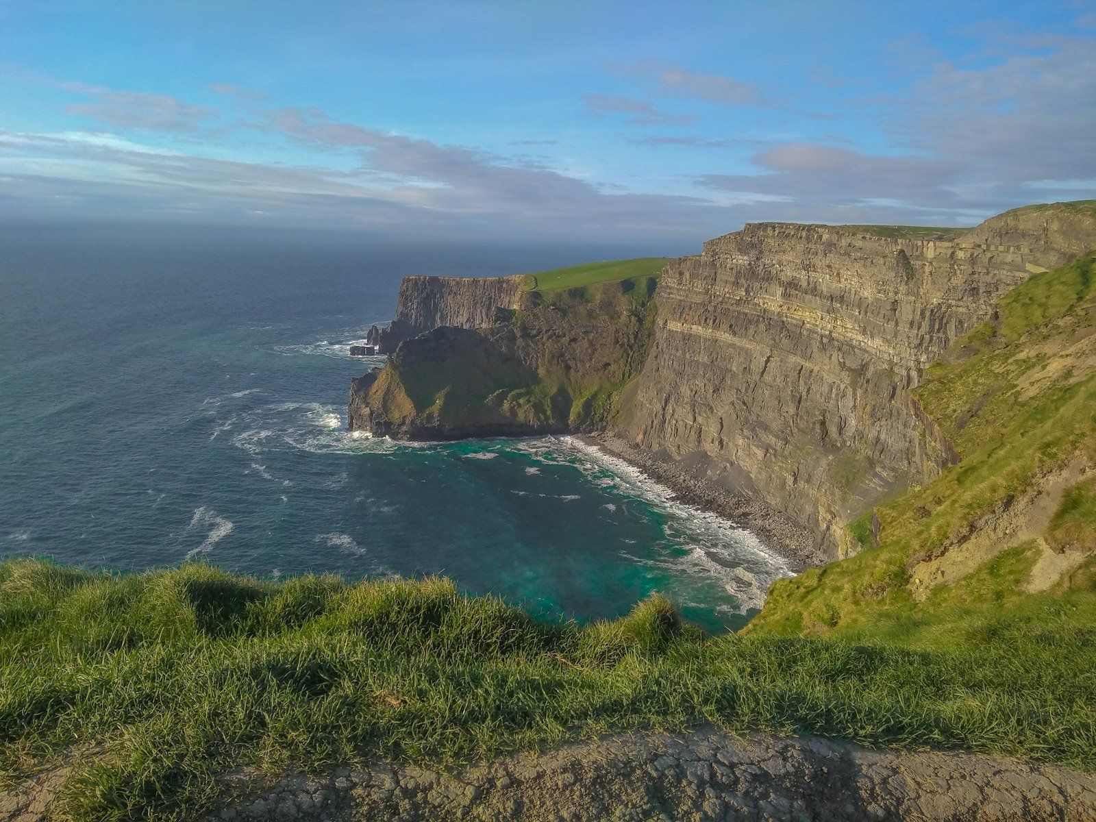 The Cliffs of Moher are sea cliffs on the west coast of Ireland in County Clare, known for their dramatic drops into the Atlantic Ocean and panoramic views. They stretch for about 14 kilometers and are a popular part of the Wild Atlantic Way, with their highest point reaching 702 feet near O'Brien's Tower. Visitors can enjoy walking trails, birdwatching, and a visitor center, with admission fees typically required for access, though some can walk to the cliffs from nearby towns like Doolin or Liscannor